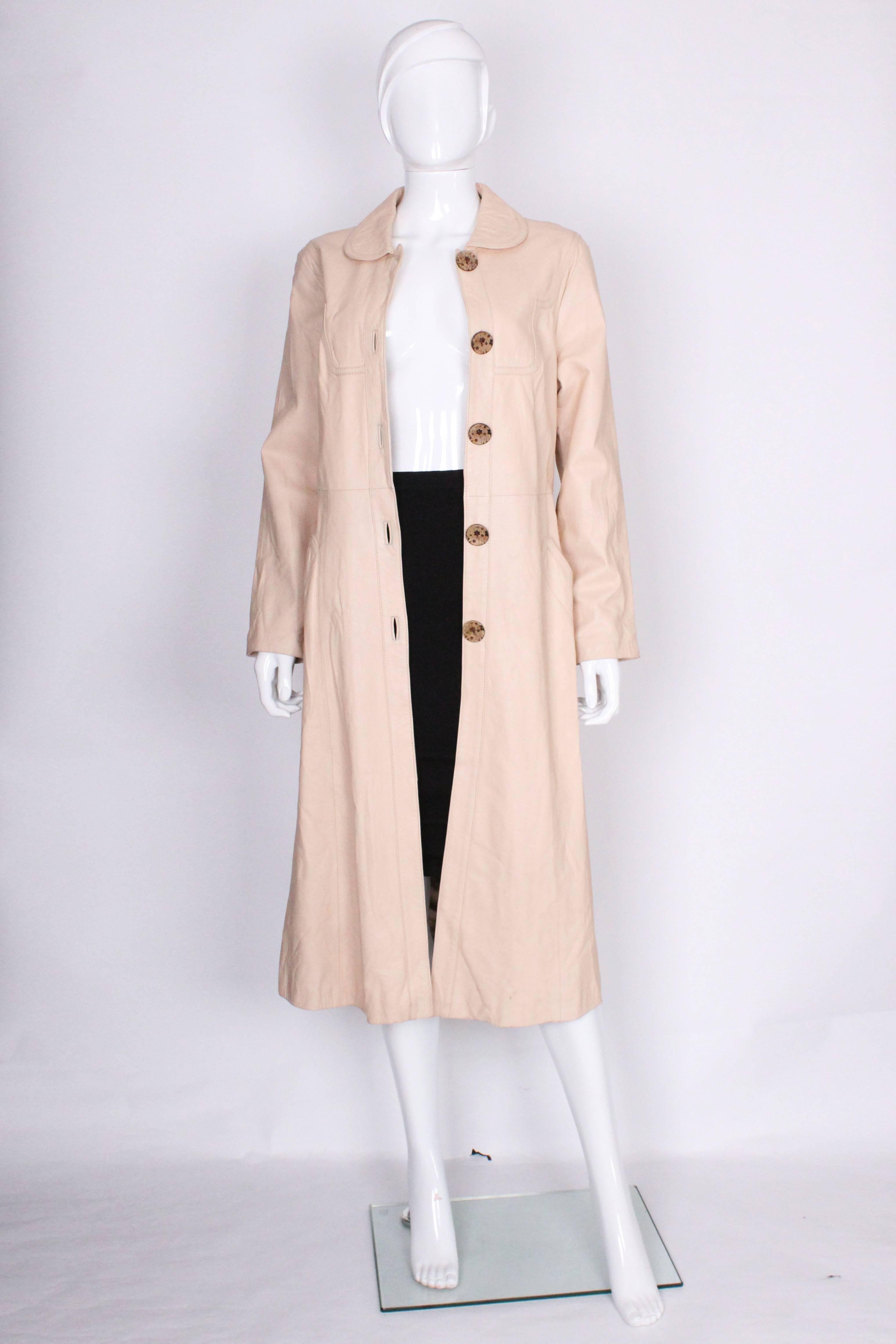 A super chic leather coat by Pierre Cardin , Paris. In a pale bisucit colour and super soft leather , this coat is a great addition to an Autumn wardobe. It has a round collar,double stitch detail on the yoke , 5 button opening and a leather belt