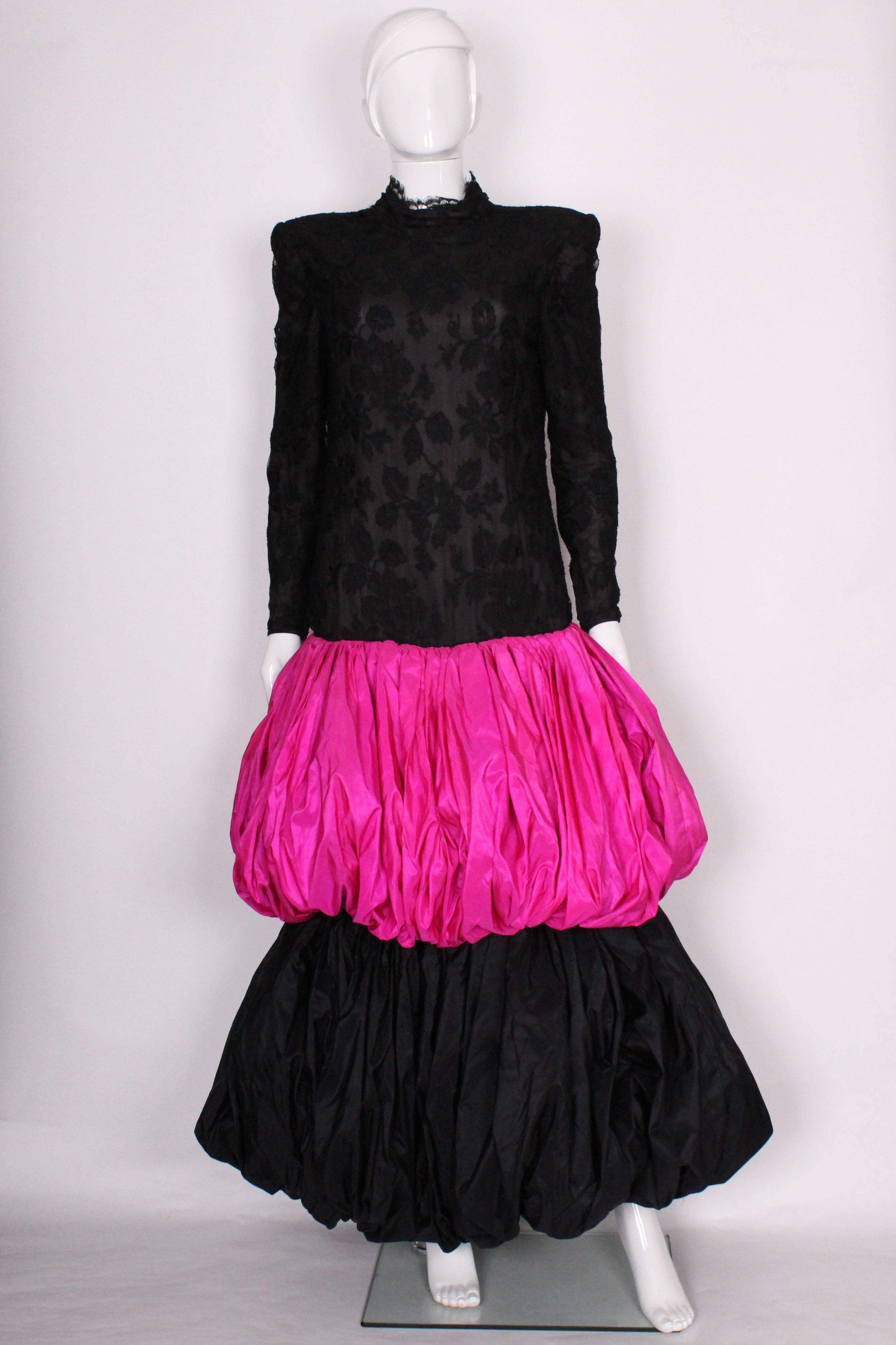 A great gown by Italian designer Valentino.This head turner has a black lace upper part , leading to a pink taffeta puff ball,and lower black puff ball.The dress has a stand up collar,  central back zip and zip closure on the sleaves.