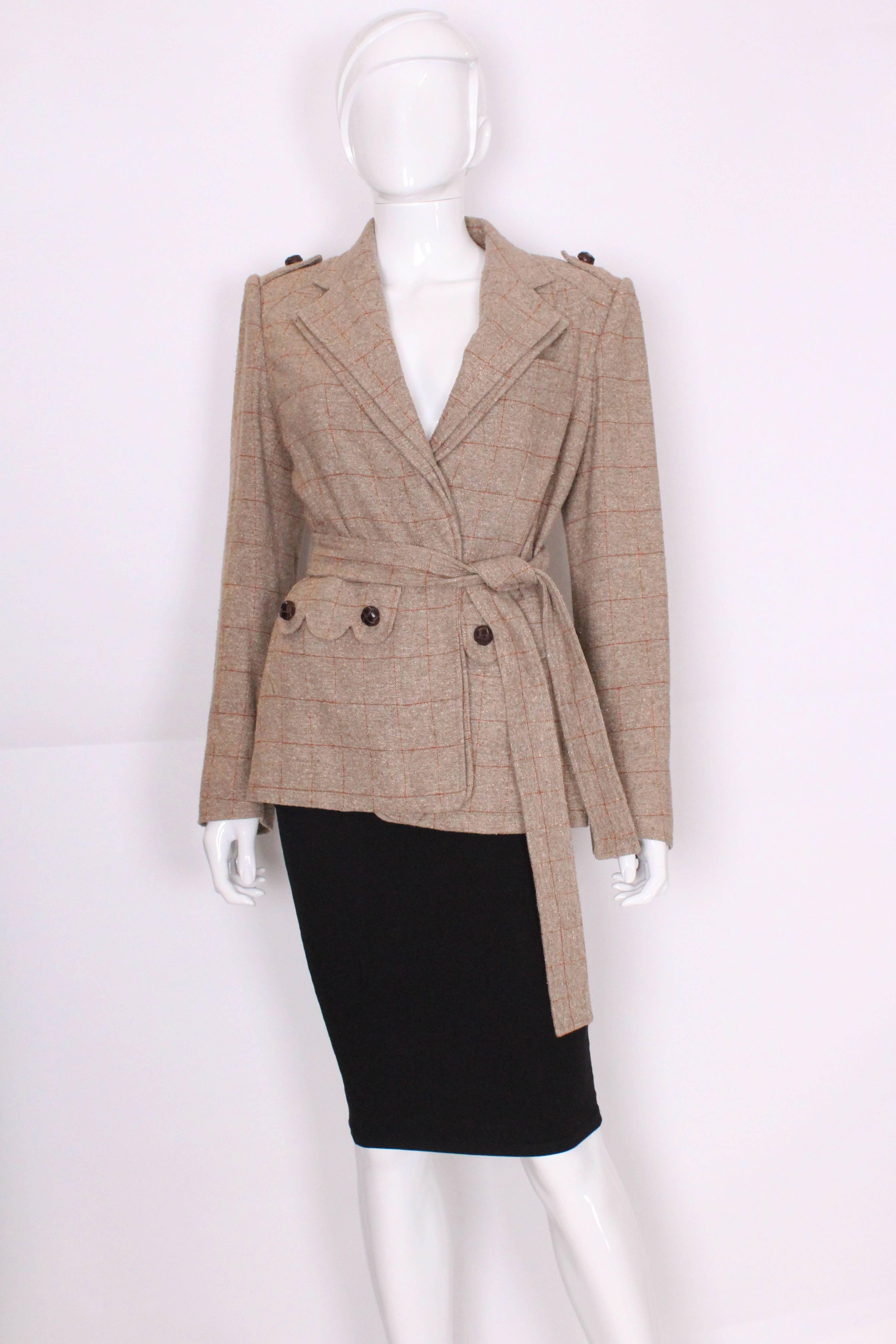 A great jacket for Fall from Yves Saint Laurent, Rive Gauche .The jacket is in a silk/linen mix, in a light brown speckled fabric with tan lines.It has one breast pocket on the left hand side and two pockets at waist level. The buttons are covered