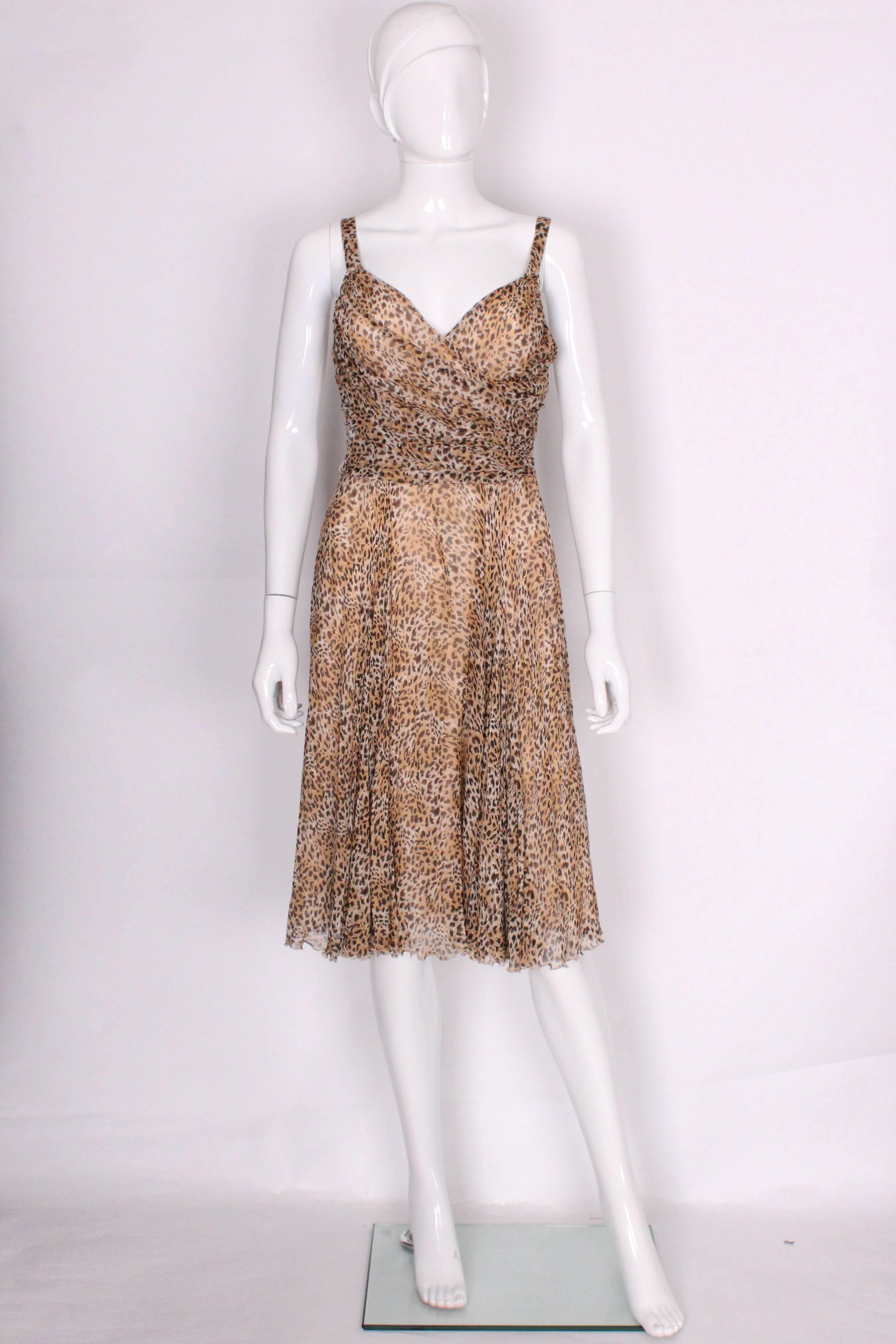 A great party dress by Italian firm La Perla. The dress is in a tasteful animal print silk, with cotton lining. It has a wrap over v neckline at the front with gathering at the back. The dress has a belt in the same fabric and the shoulder straps