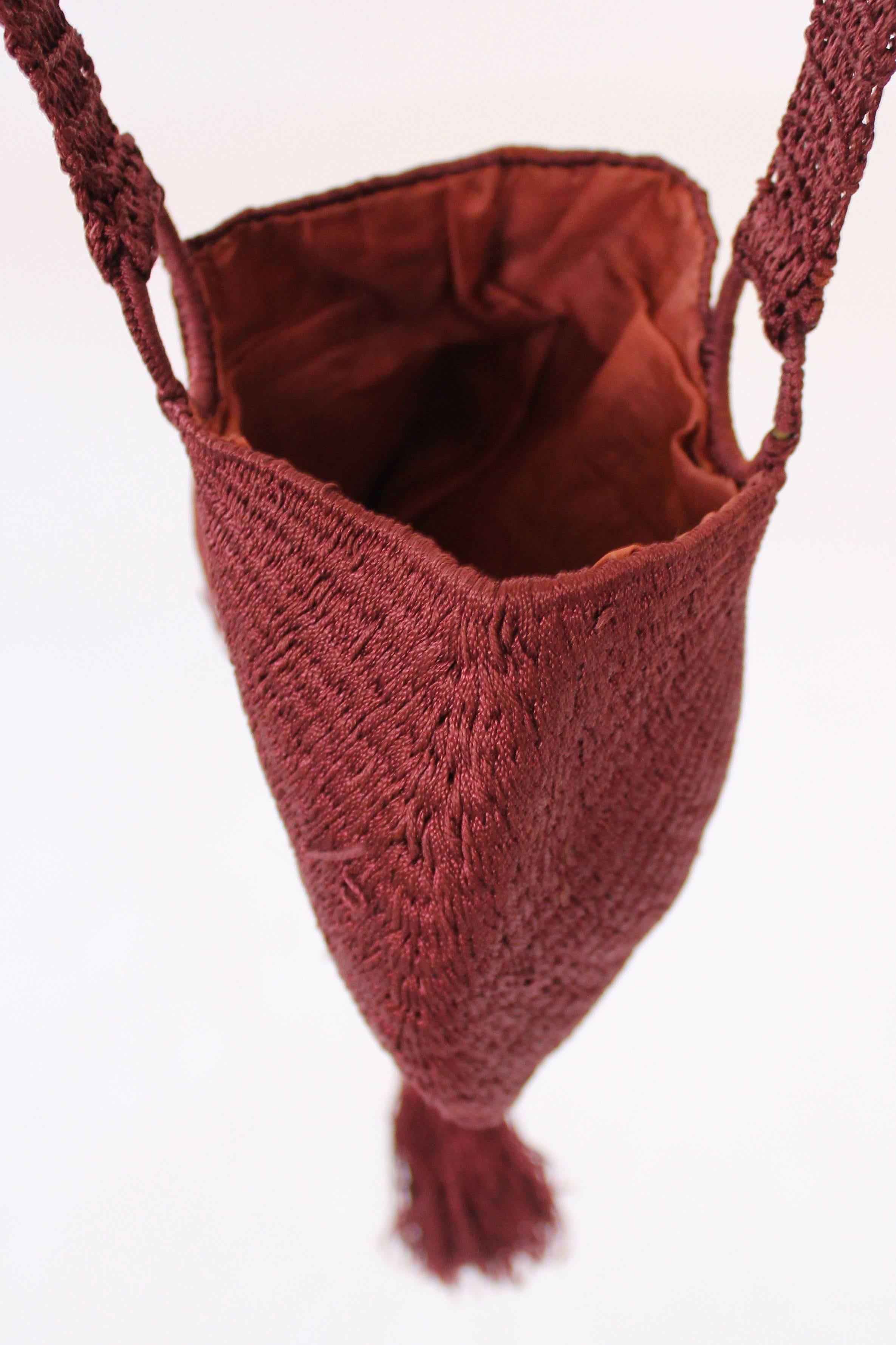 This stunning little 1920s flapper bag is made of a crochet silk thread in a fan like shape. There is one handle that loops from the front to the back of the bag and holds on to a hoop each side. The handle is made of a long looped, chunkier crochet