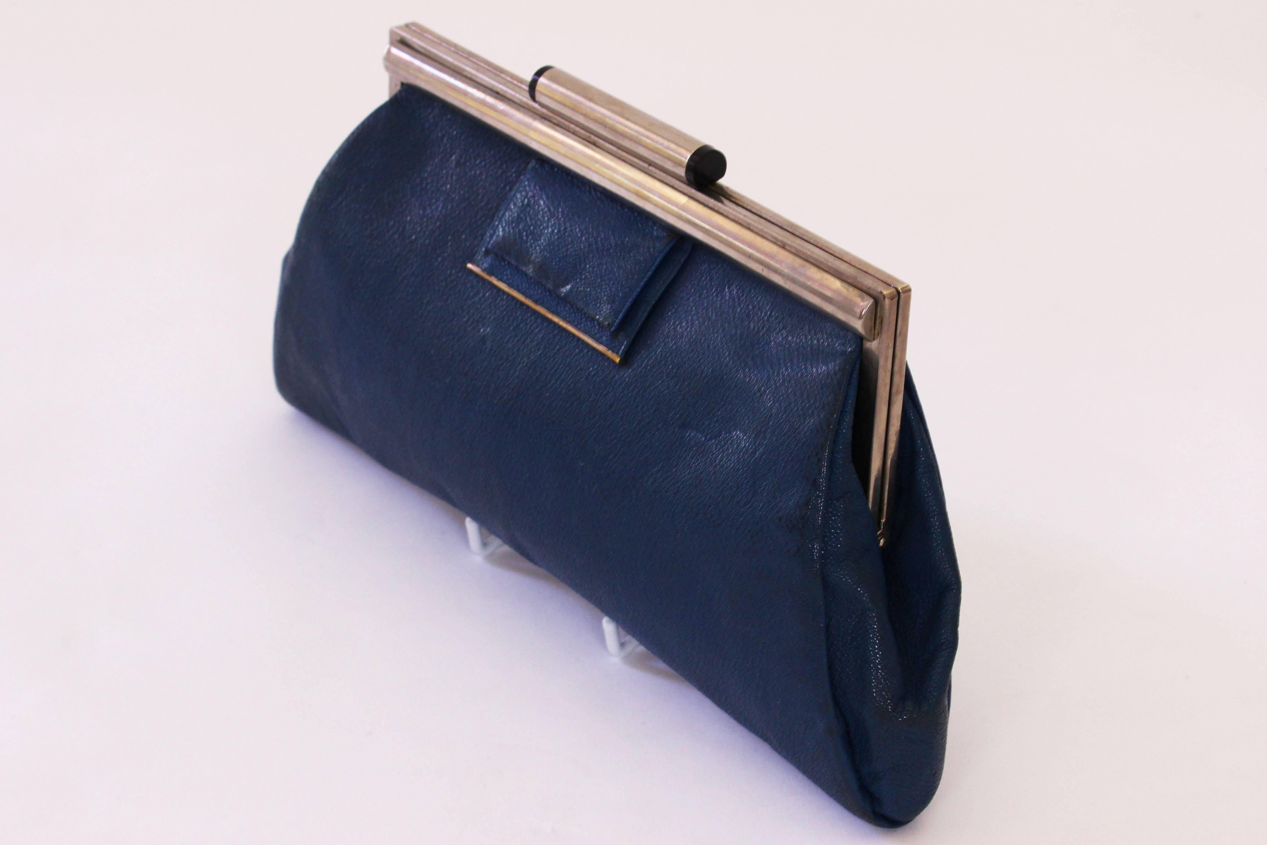 A chic and charming Art Deco style bag in a hard wearing blue leather, with a silver frame and clasp. The bag is in a sea blue leather with finger clasp at the back. The lining is blue and there is an internal purse with two compartments and an