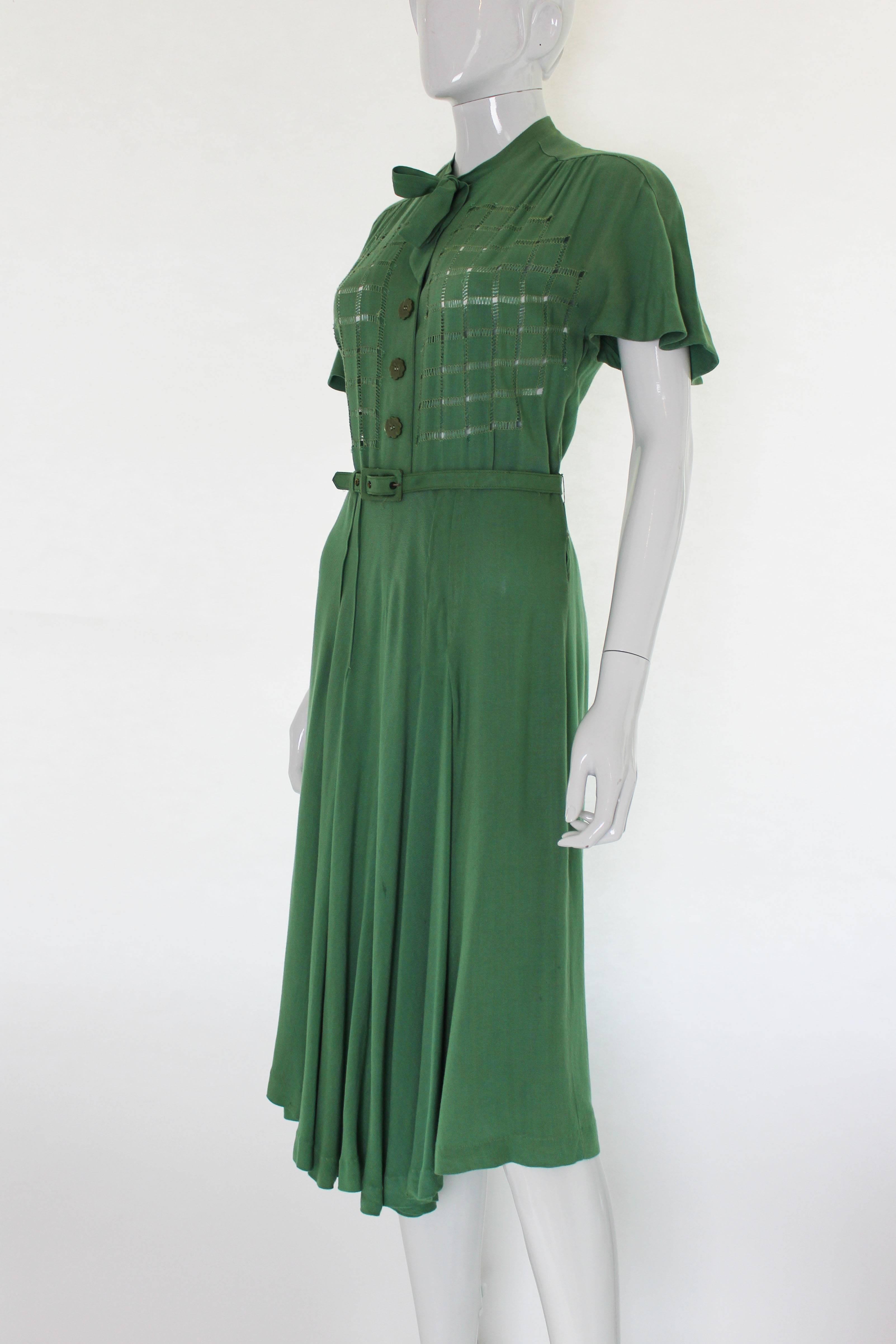 A great 1940s day dress in pistachio green. The fabric is a silk /viscose mix. This dress has wonderful detail and hangs beautifully. It has a tie neck, three very pretty buttons and pretty stitch detail on the front. There are four pleats on the