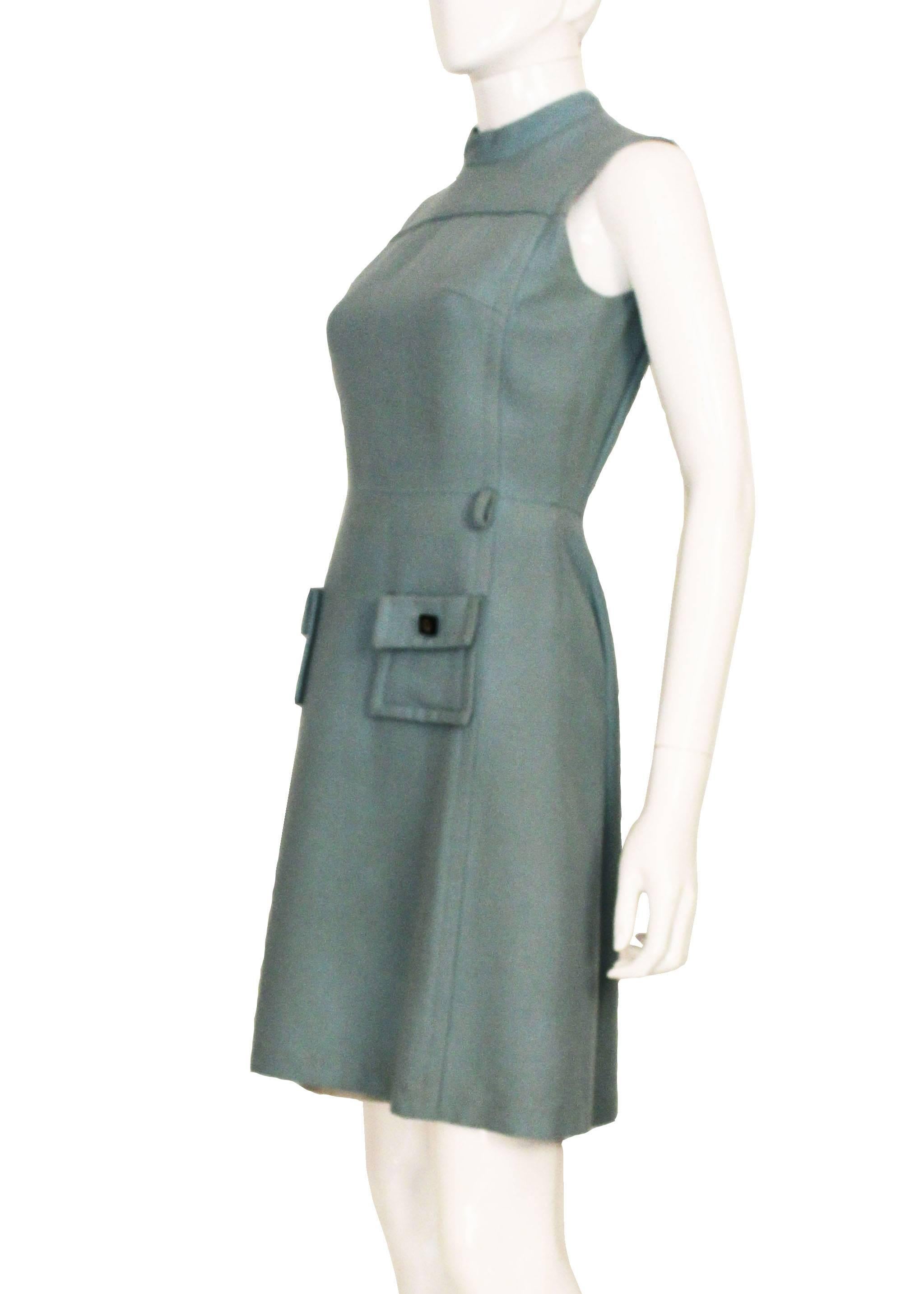 This cute little 1960s mod dress is a great example of its era. It is a great A-line shape, is beautifully tailored and really well made. There are 2 square pockets on the front wide stitch detailing around them and a black square button with a gold