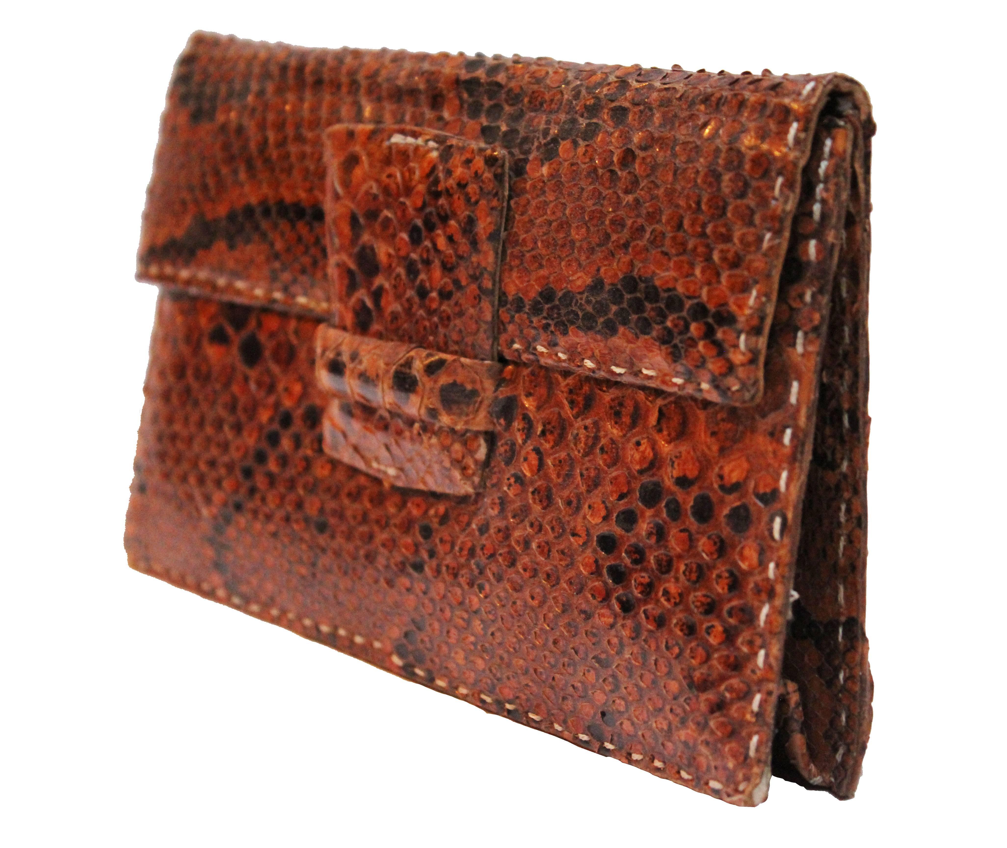This is a really gorgeous little snake skin clutch bag in a rich dark tan colour. It is in near perfect condition, and a really gorgeous shape. It has a small pocket inside and is a great size to fit all of your essentials in. The fastening is a