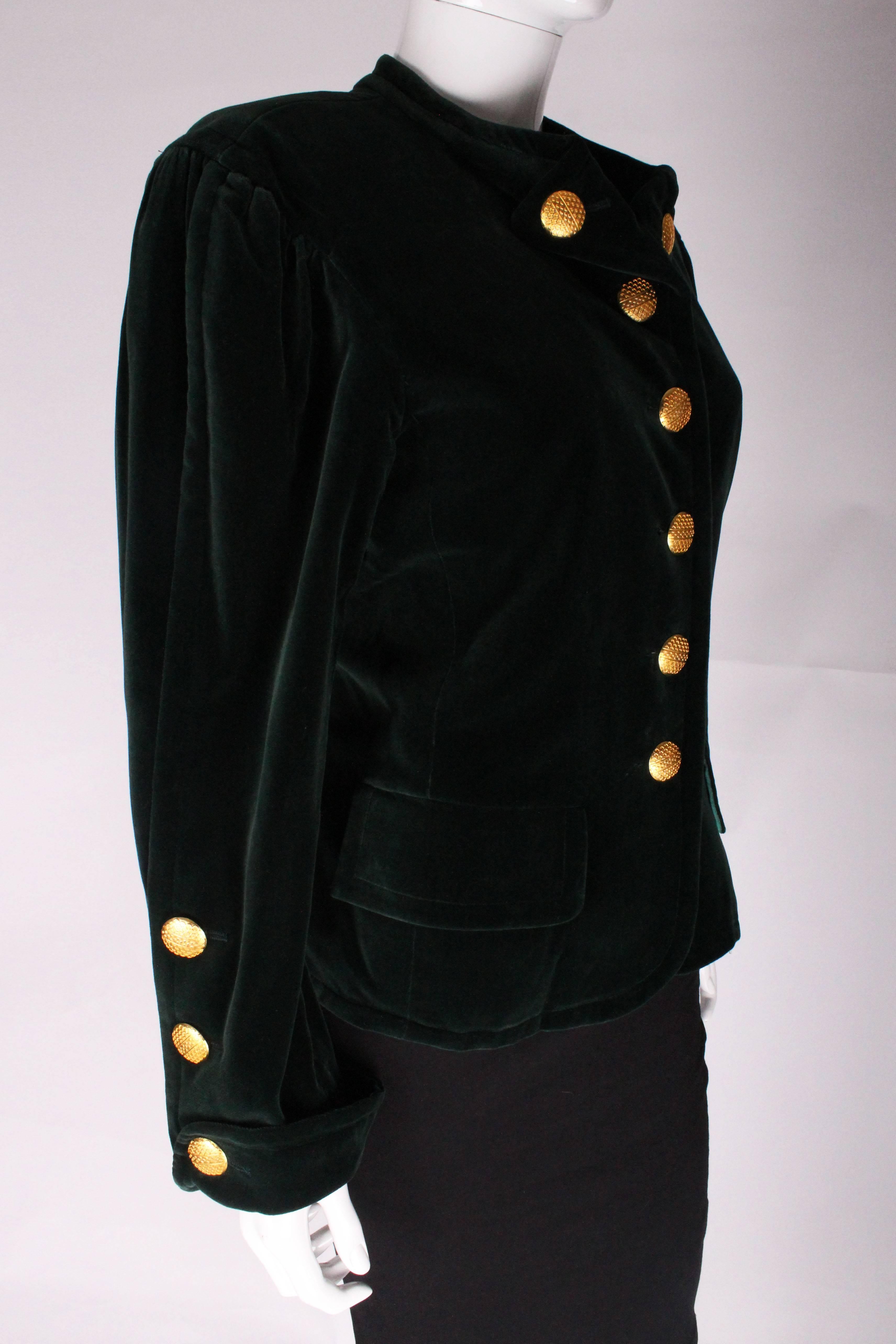 
A great jacket by Yves Saint Laurent, Rive Gauche line. In a great green velvet with crimson lining, and glorious gold buttons, this jacket is a real head turner.
The jacket has a button down collar, and  2 pockets on the front at hip leval.