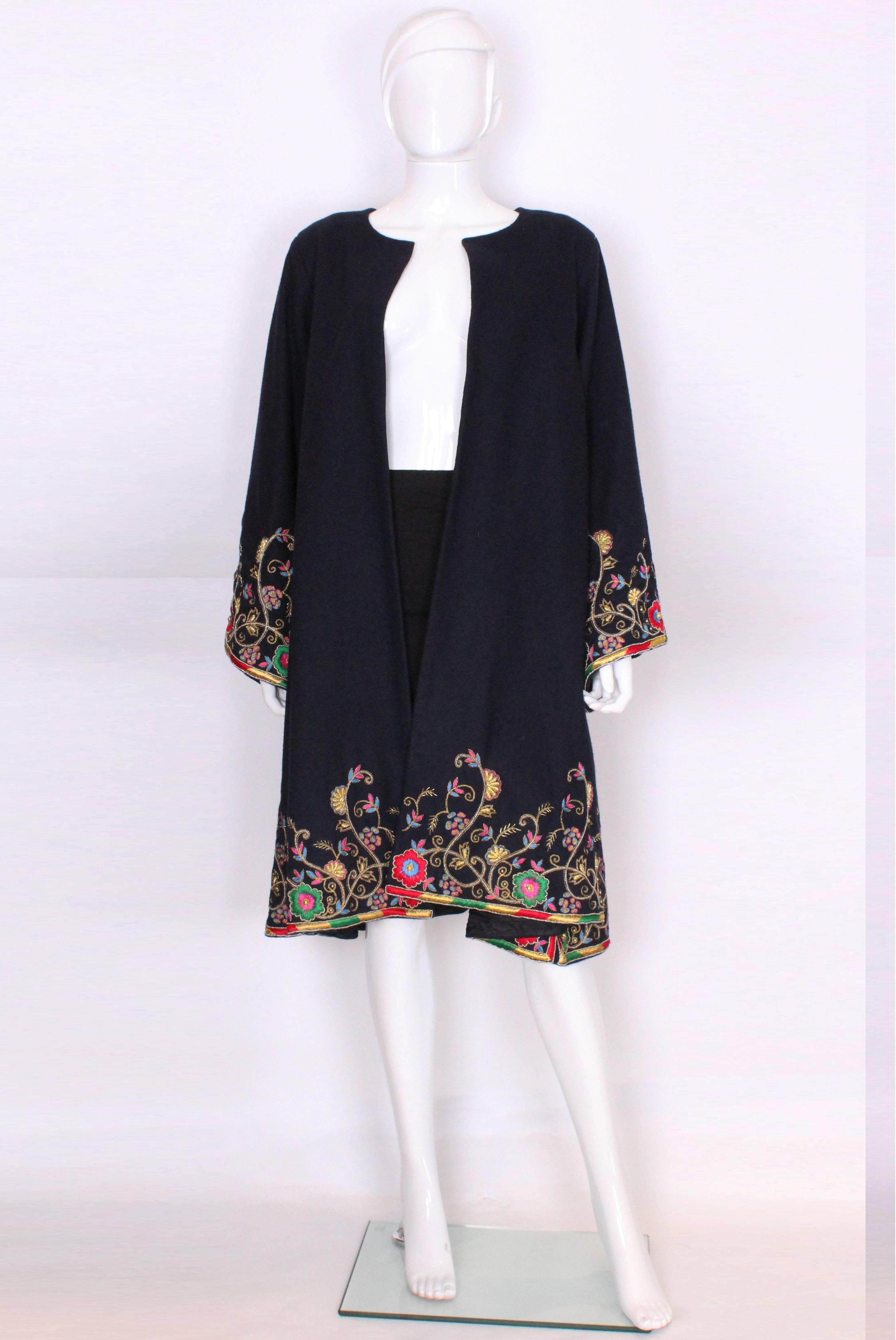 A great coat to brighten up a winter day. Made in a dark navy wool and fully lined in a dark navy silk/poly. This coat is heavily and brightly embroidered around the  cuffs of the sleeves and at the hem line. The colours include gold, red, blue,