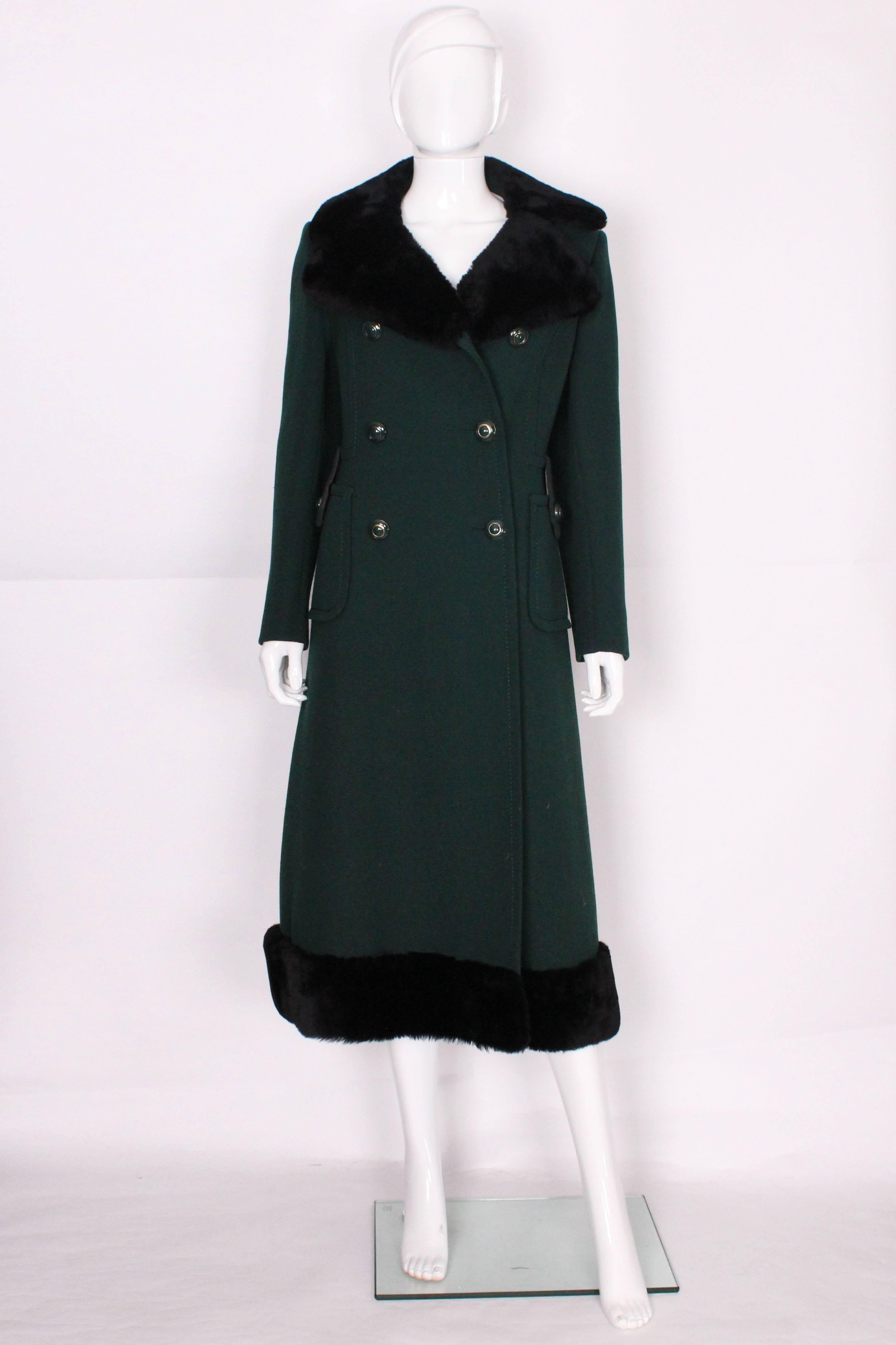 This chic coat is made of really high quality dark pine green wool. There is a black faux fur collar and trim at the hem. It is double breasted with 3 rows of green and gold buttons on either side. There are also 2 mtching buttons on the large patch