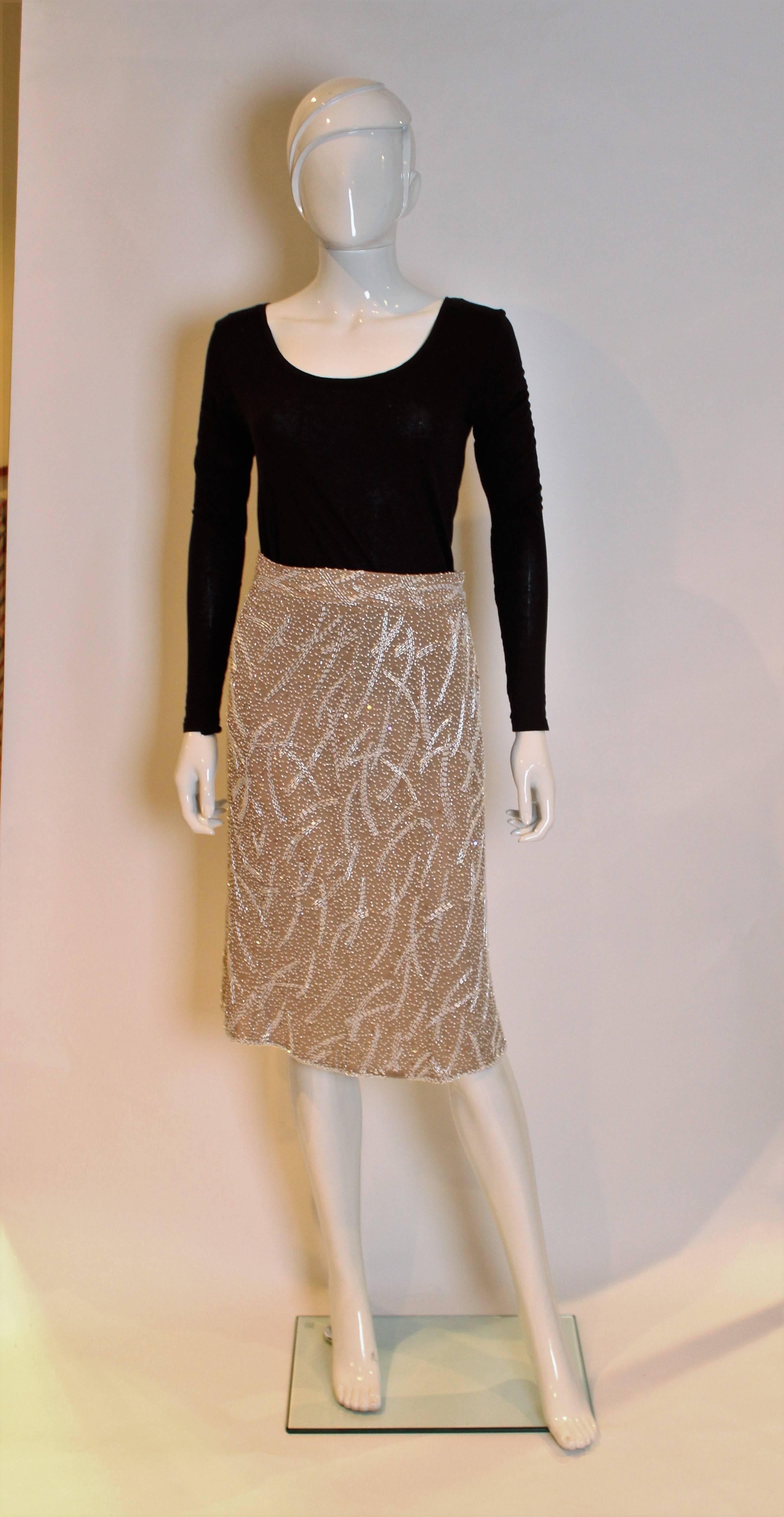 A great skirt by Tomasz Starzewski. In coffee coloured silk,inside and out, the skirt is covered in white beads and sequins.The skirt has a central back zip.



