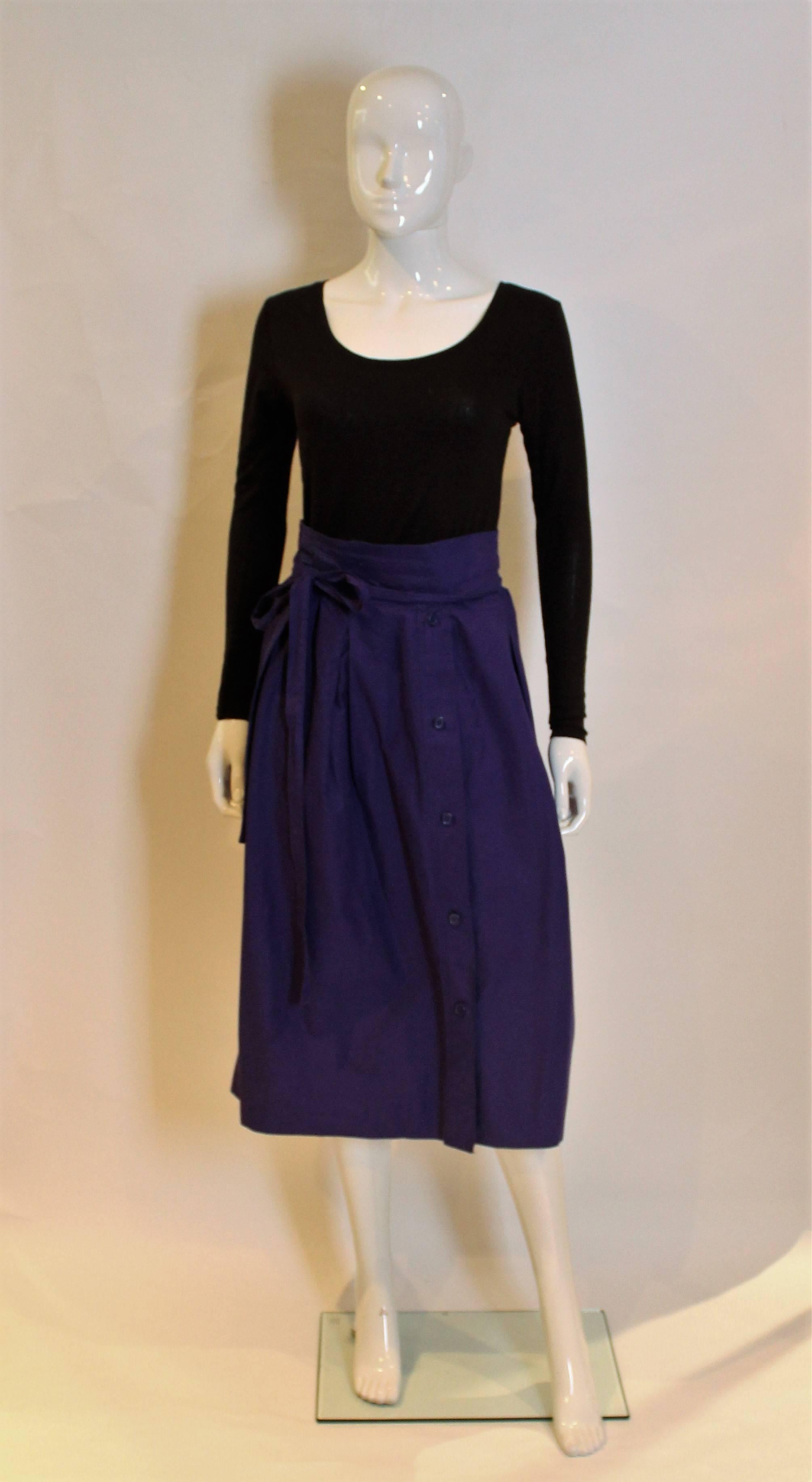 A stunning skirt by Yves Saint Laurent .The skirt is in a wrap around style with stitch detail on the waist , a five button opening on the front and a pocket on either side.