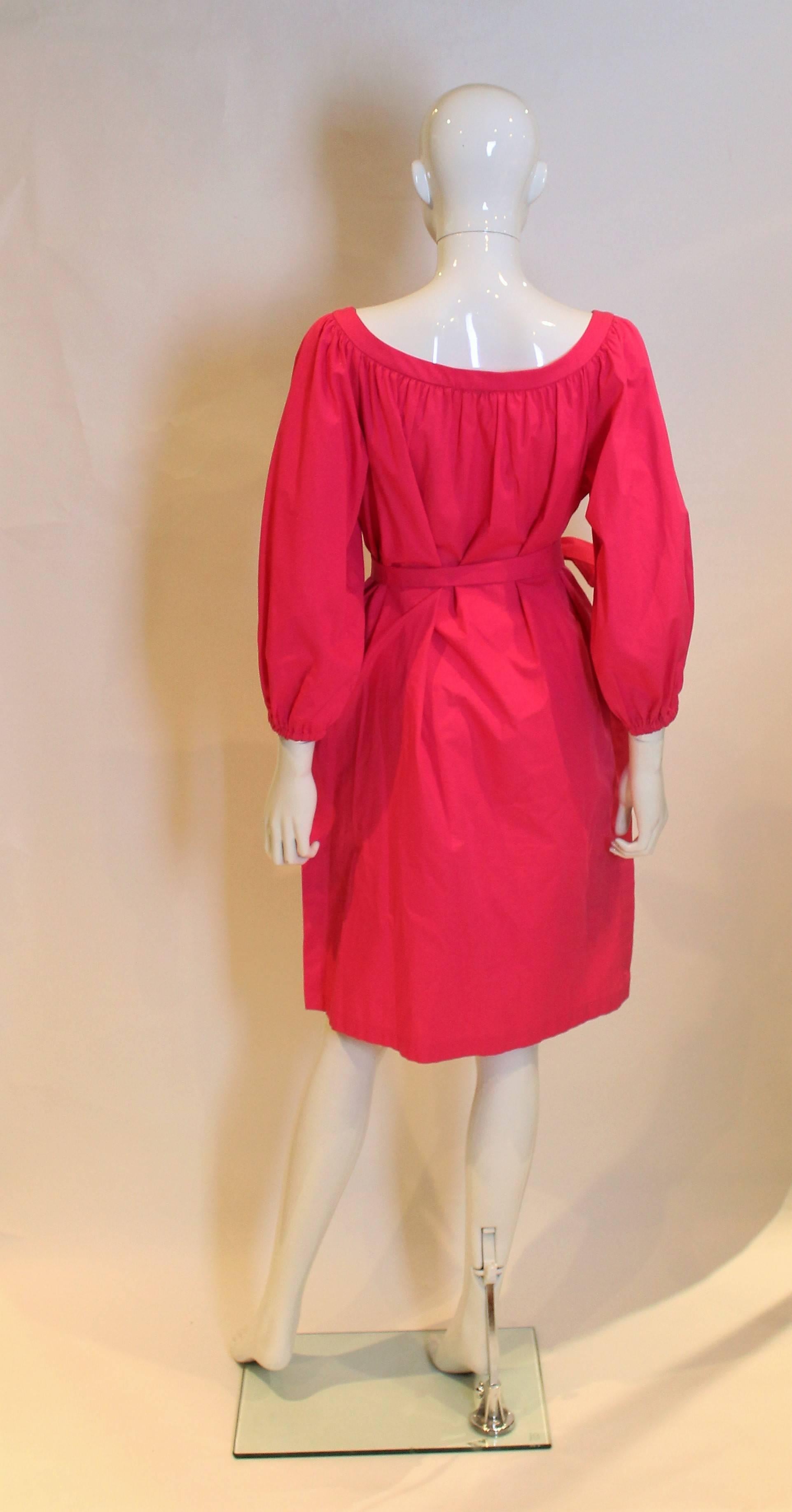 A great dress for Spring/Summer by Yves Saint Laurent Rive Gauche. In a pretty pink colour, this cotton dress has a round neckline, elbow length sleeves and a pocket on either side. There is an 11'' slit on either side, and a self fabric tie belt
