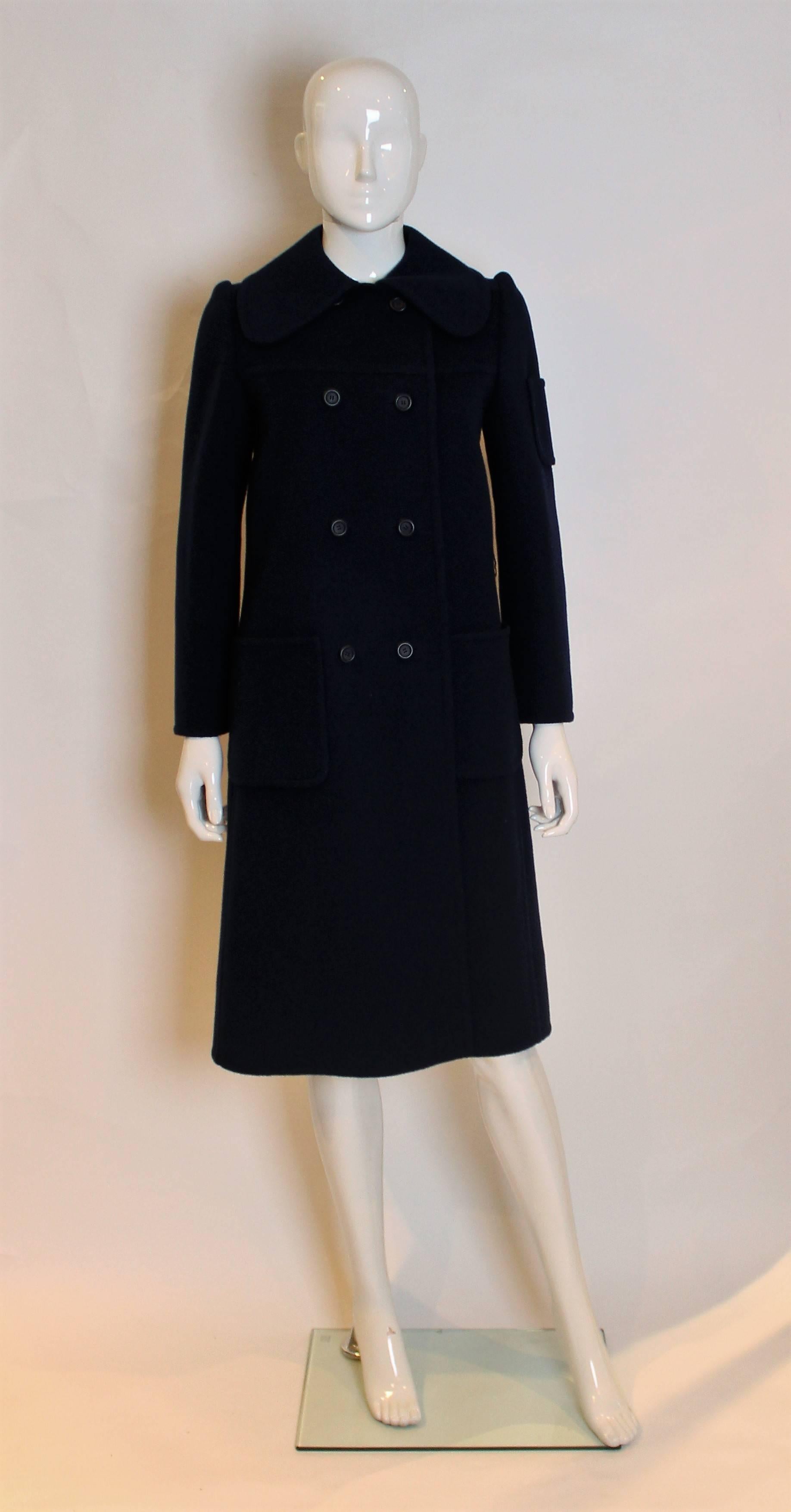 A chic coat by Christian Dior, Patron Original number 002000. In a dark blue wool, this coat is unlined and has a round collar , two rows of four buttons and two pockets.-