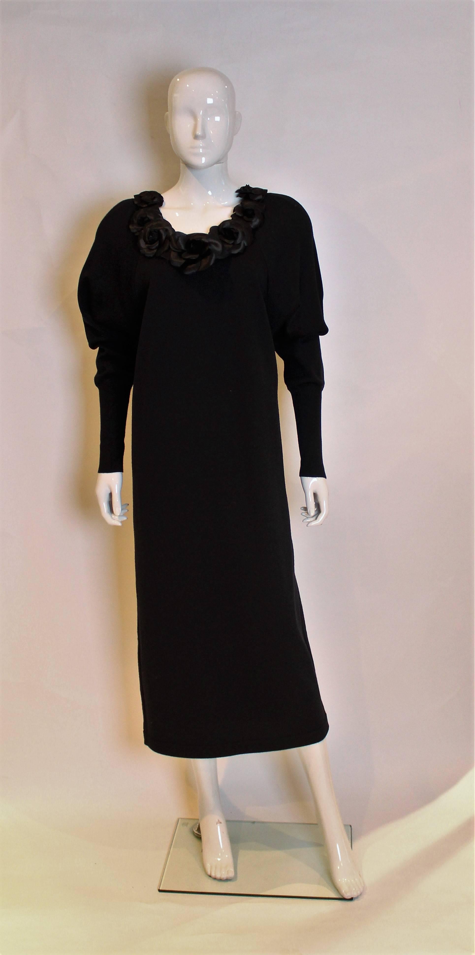 Chic and easy to wear dress from Chanel.
This sweater dress has a scoop neck,long sleeves with elegant 8'' long cuffs, and silk camelias  along the neckline.