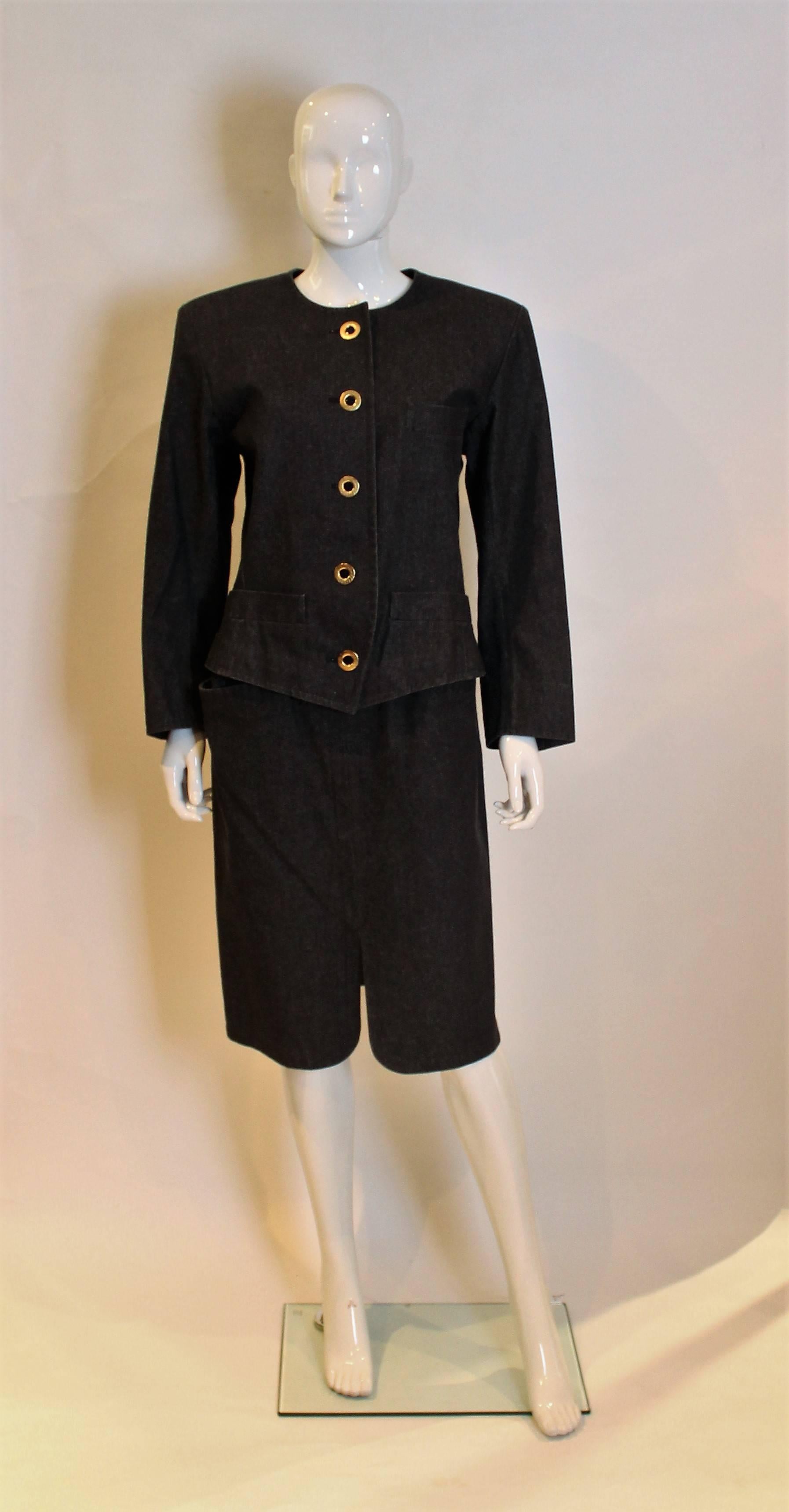 A great suit for Spring. This black skirt suit  has a round necked jacket with 5 button front opening. It has 3 buttons on each cuff, one breast pocket on the left hand side and 2 pockets at hip leval. The skirt has a zip opening on the left hand