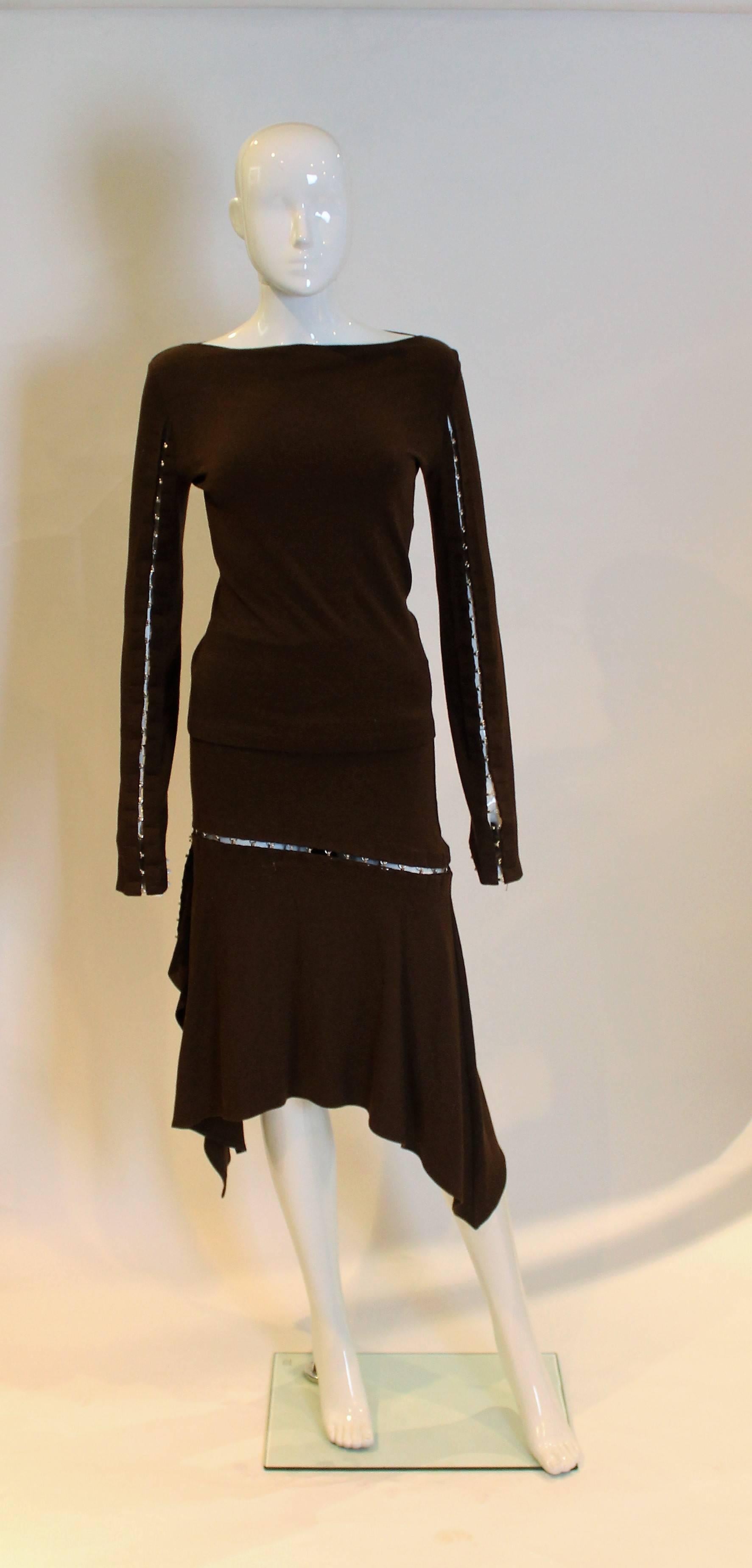 A seriously sexy outfit from Plein Sud. The top has a  slash neckline with hook and eye opening along the sleeves. The skirt has a row of hooks and eyes running from the right hand side and front and back of the skirt.
Top:Bust 33'',length 21''