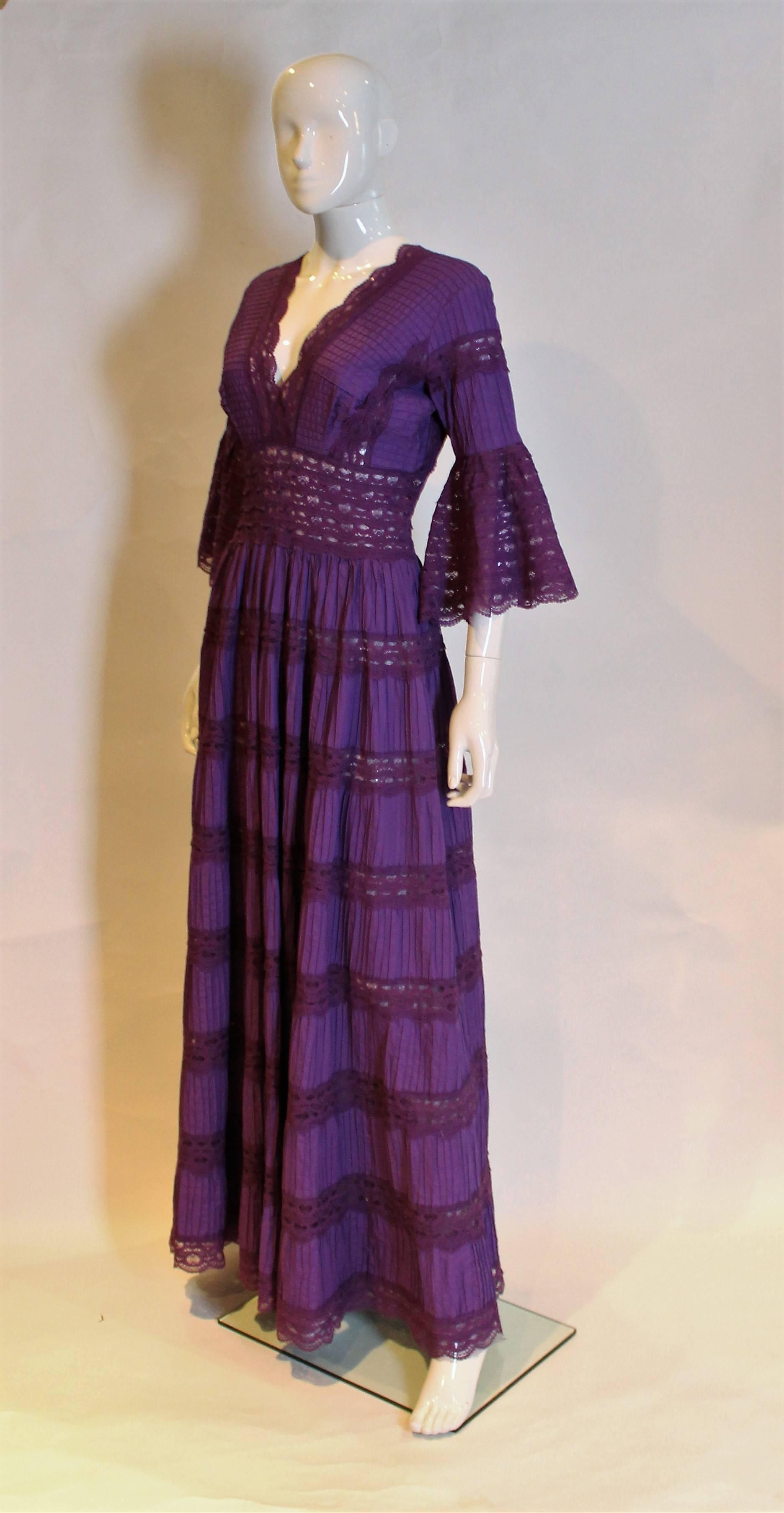 A great Mexican evening gown by Rodamex. In cotton and lace , this purple gown is a real head turner. The dress has a v neckline at the front and back, with pintuck cotton and lace panels.The dress has a central back zip, and fluted sleeves trimmed