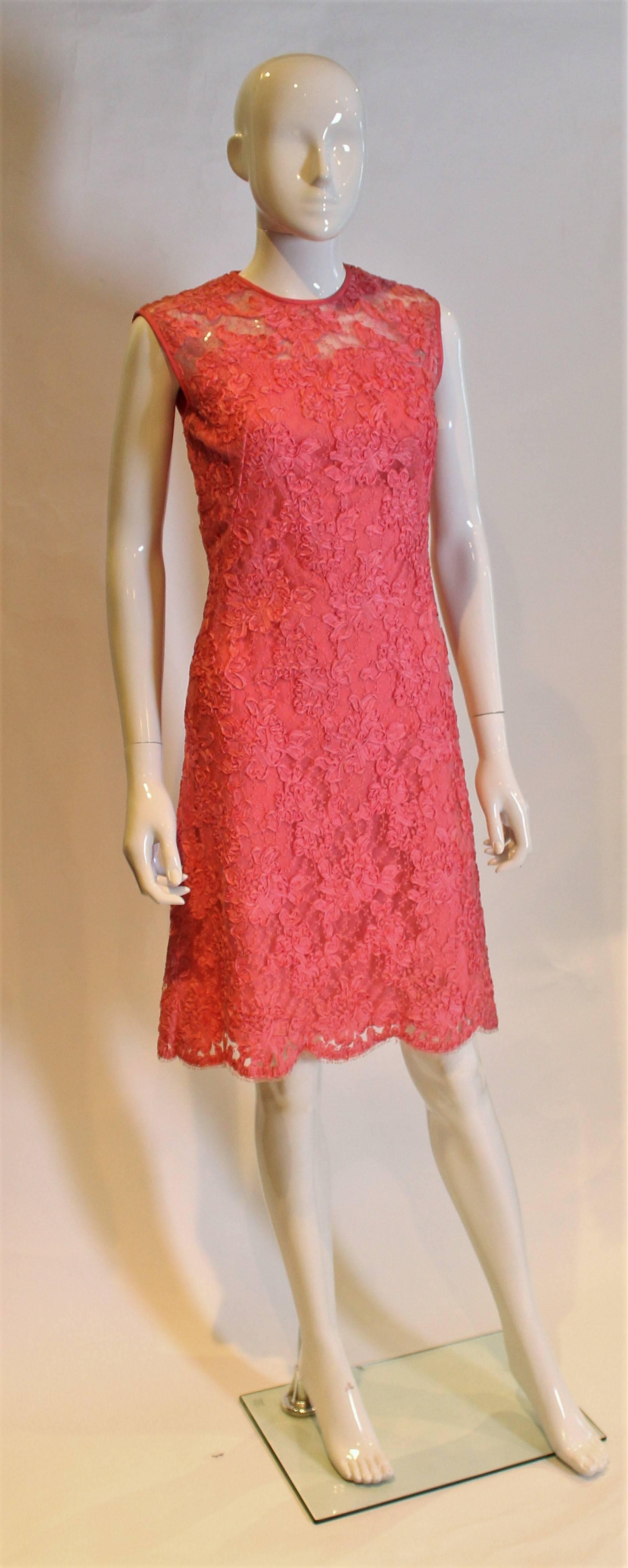 A chic and pretty dress by Wendy.This dress has a round neck and sheer net and ribbon at the top of the bust area, and is lined below.It has a key hole opening at the back, with a central back zip  and scalloped hem.