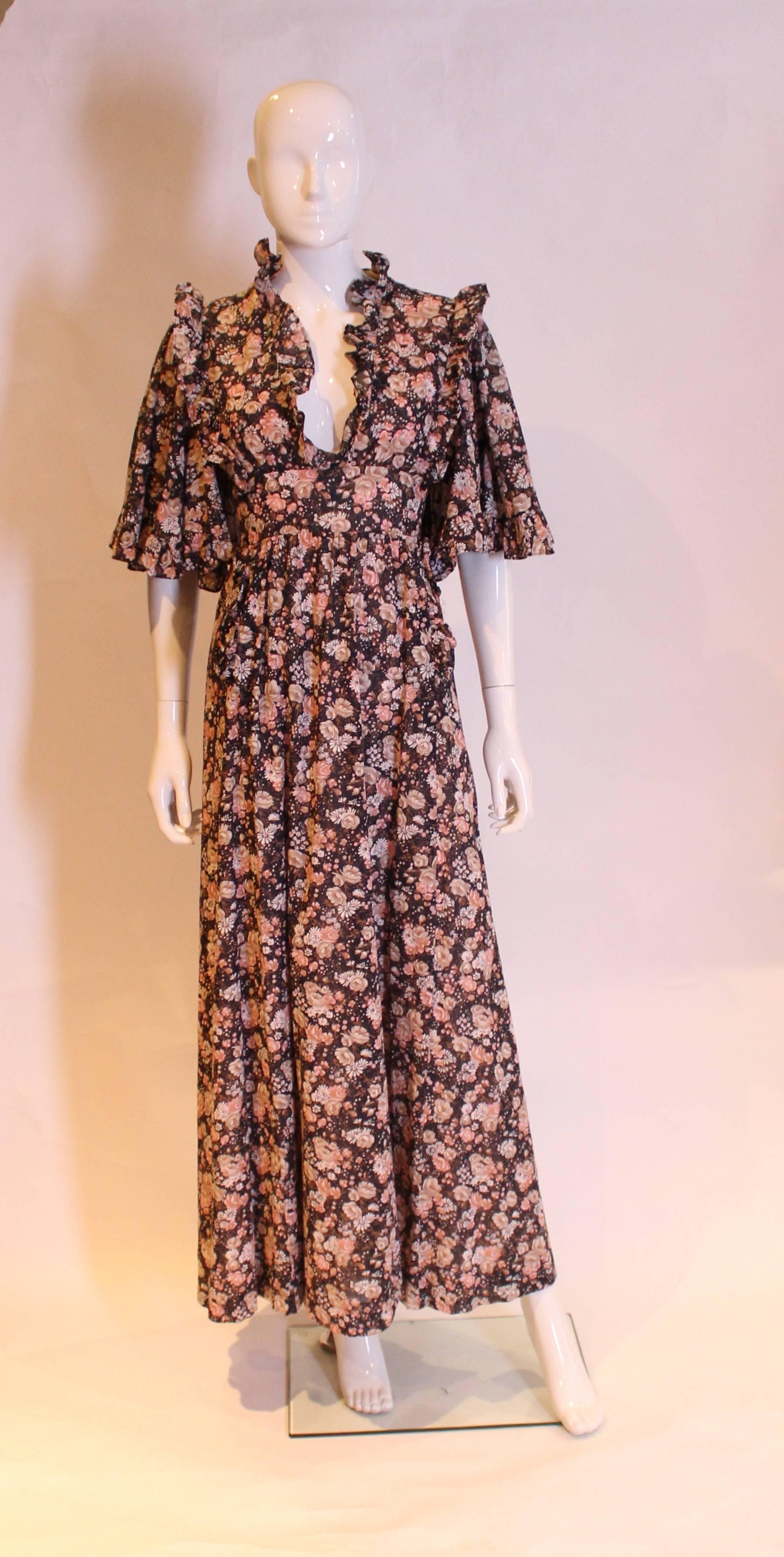 A great festival frock, by British designer Gina Fratini. In a pretty floral cotton print, the dress is fully lined and has a v neckline, 2 pockets at the front, angel sleaves , central back zip and self tie.