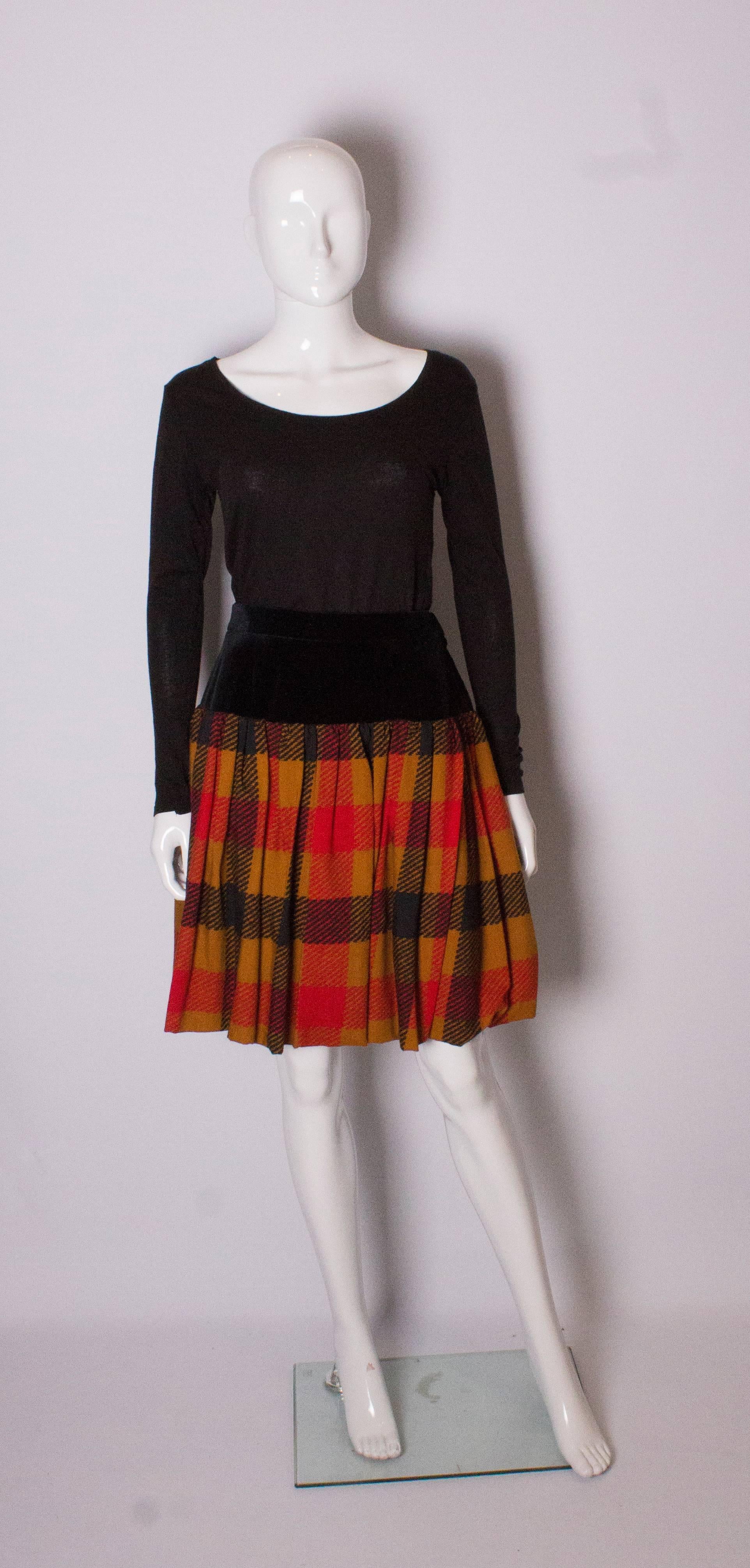 A great skirt by Yves Saint Laurent, Rve Gauche line. The skirt has a black velvet panel below the waist and then a gathered caramel check wool section. The skirt has a 6'' hem and can be let down if required. The skirt is fully lined and has