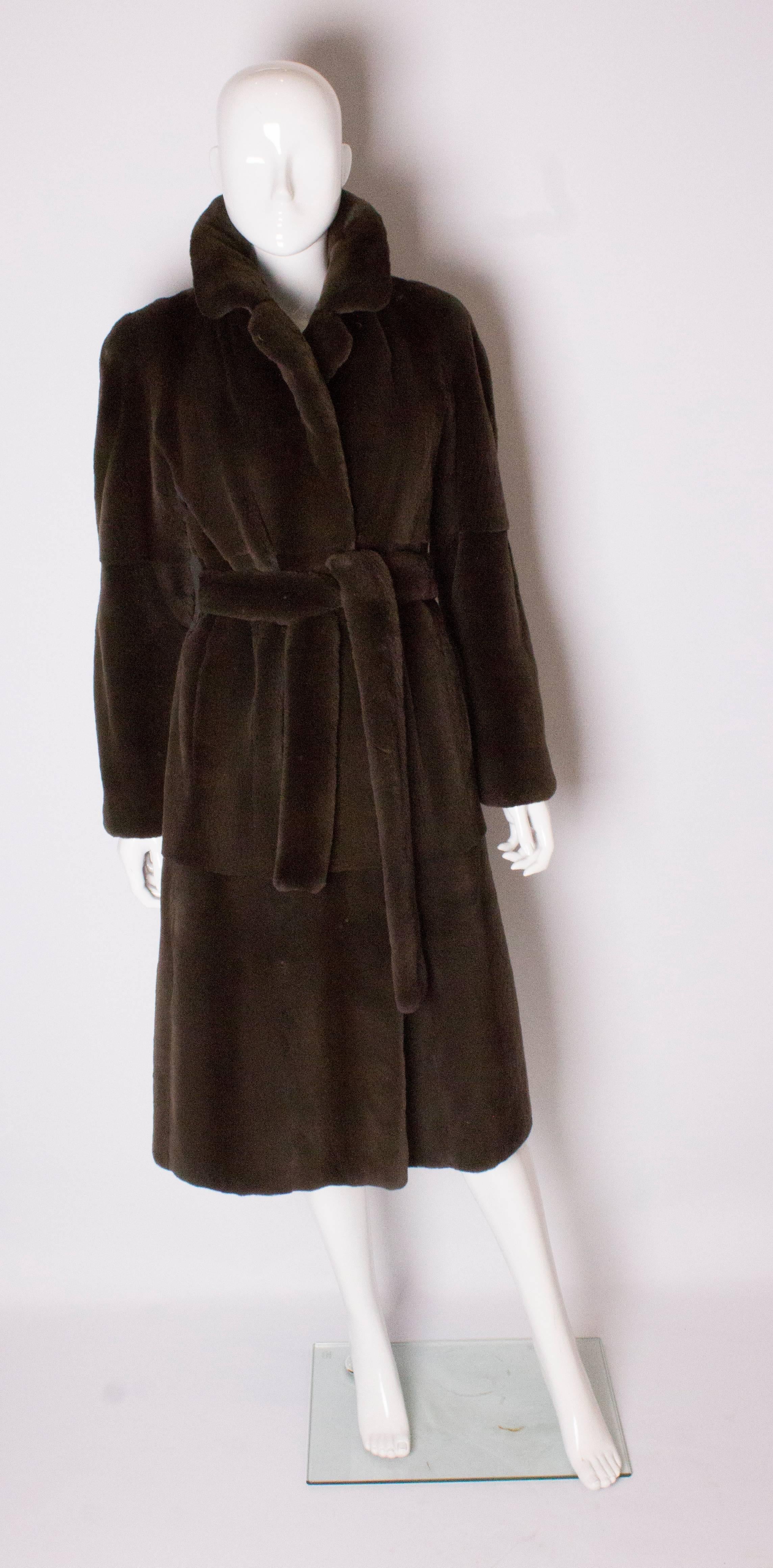 A great sheared mink coat in a wonderful chocolate brown colour. The coat has lapels ,is fully lined, has a tie belt, and the back vent can be unbuttoned.