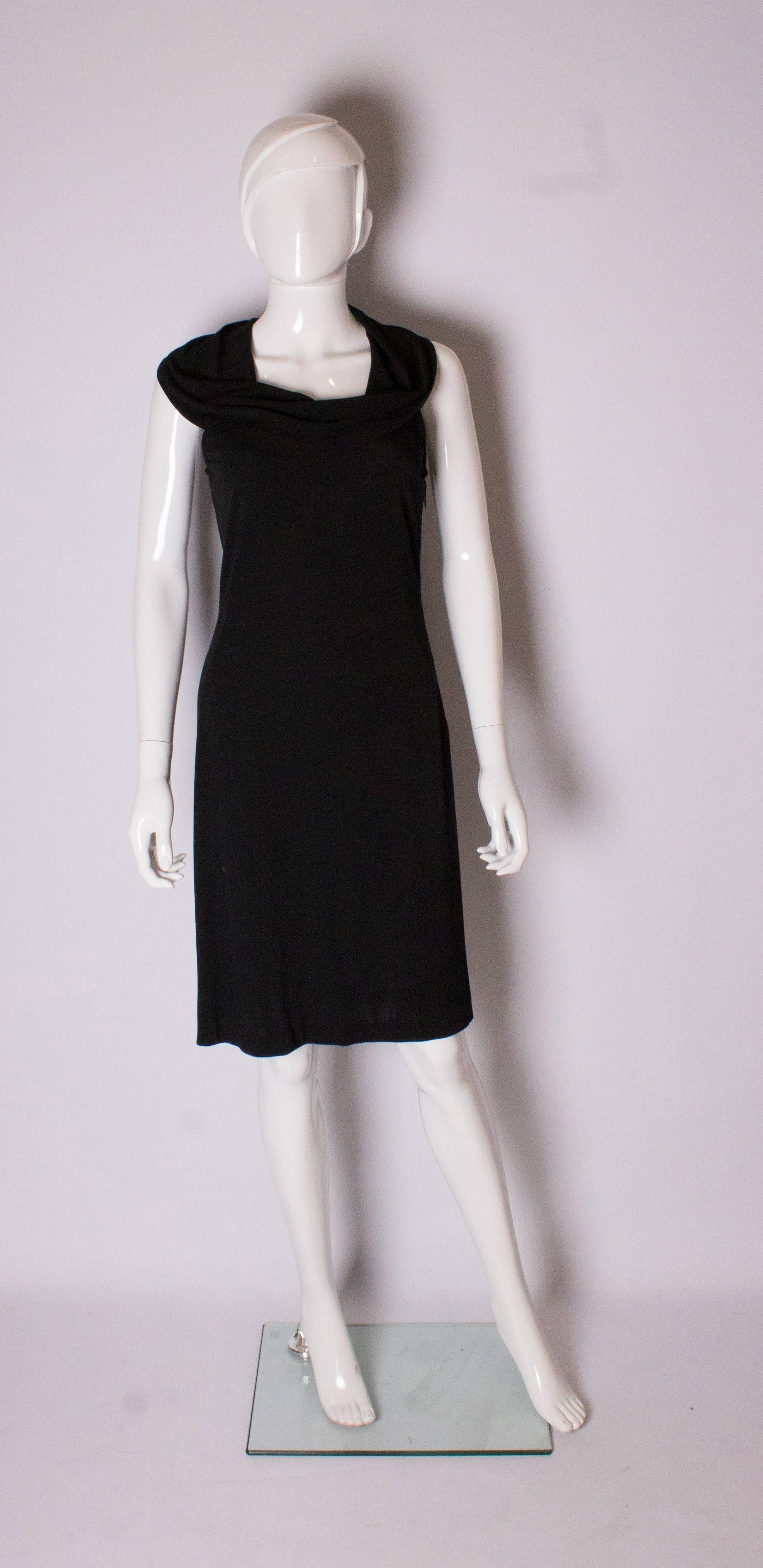 A chic cocktail dres by Oscar de la Renta. The dress is sleeeless, has a deep cowl neck and a side zip.