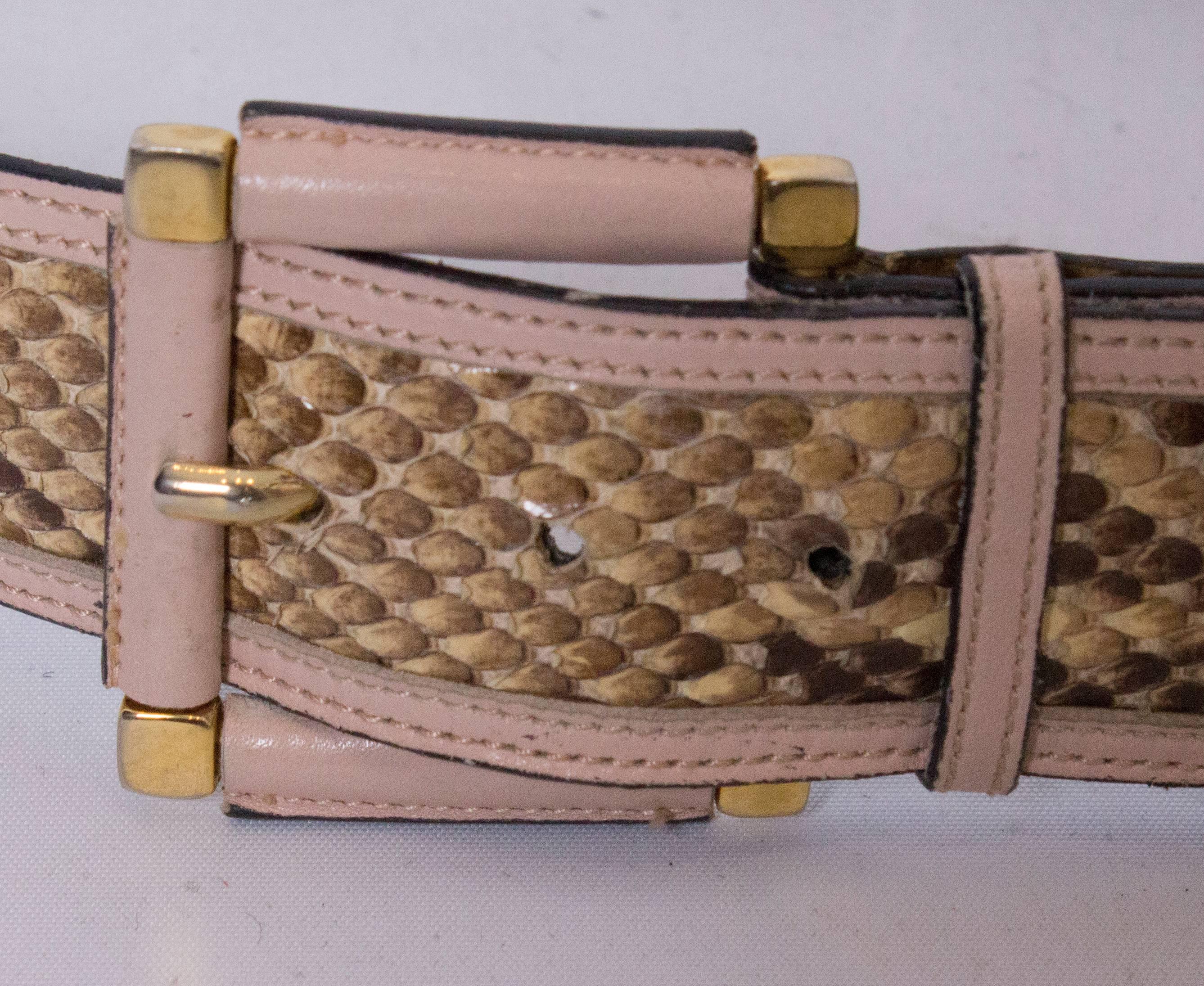 A pretty snakeskin belt by Escada.In beige snakeskin with a pale pink leather trim, and pink buckle.The belt is numbered 316  25538 , lenght 34'', height 1 1/2''.