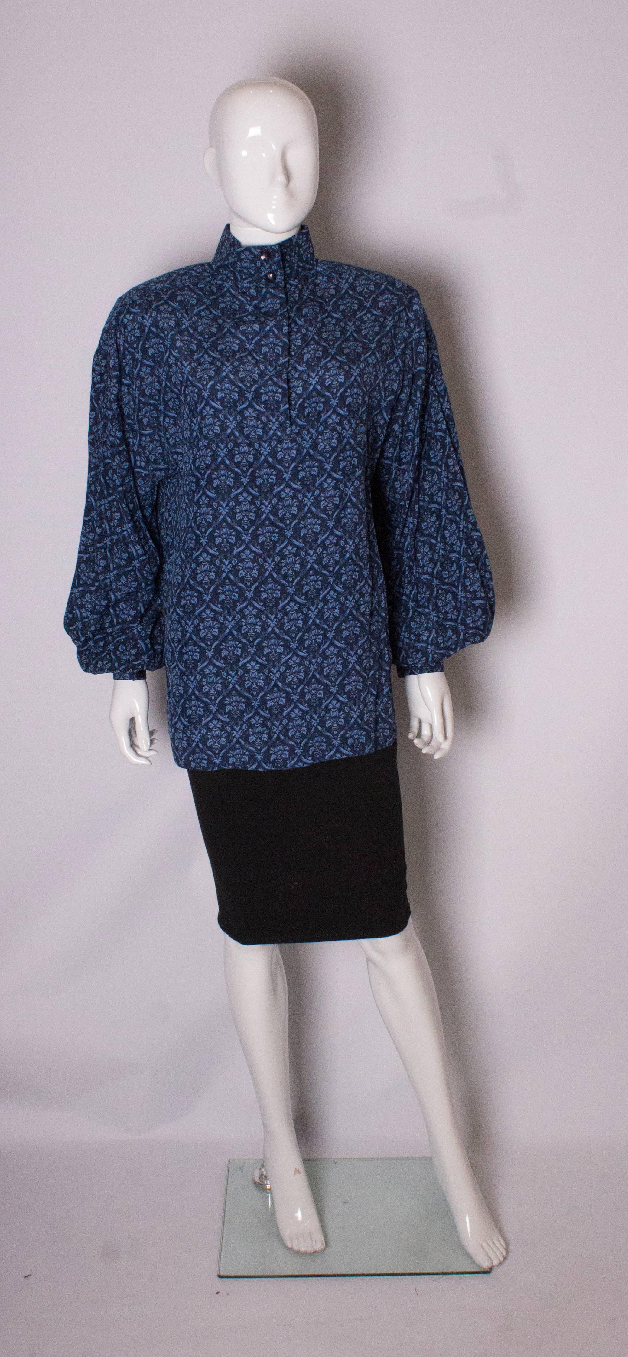 A chic silk blouse by Fendi. In a pretty pattern in several shades of blue, the  blouse has interesting stitch detail on the shoulders and collar. It has double button cuffs and a 5 button opening .Bust up to 44'', but it looks better worn loose.