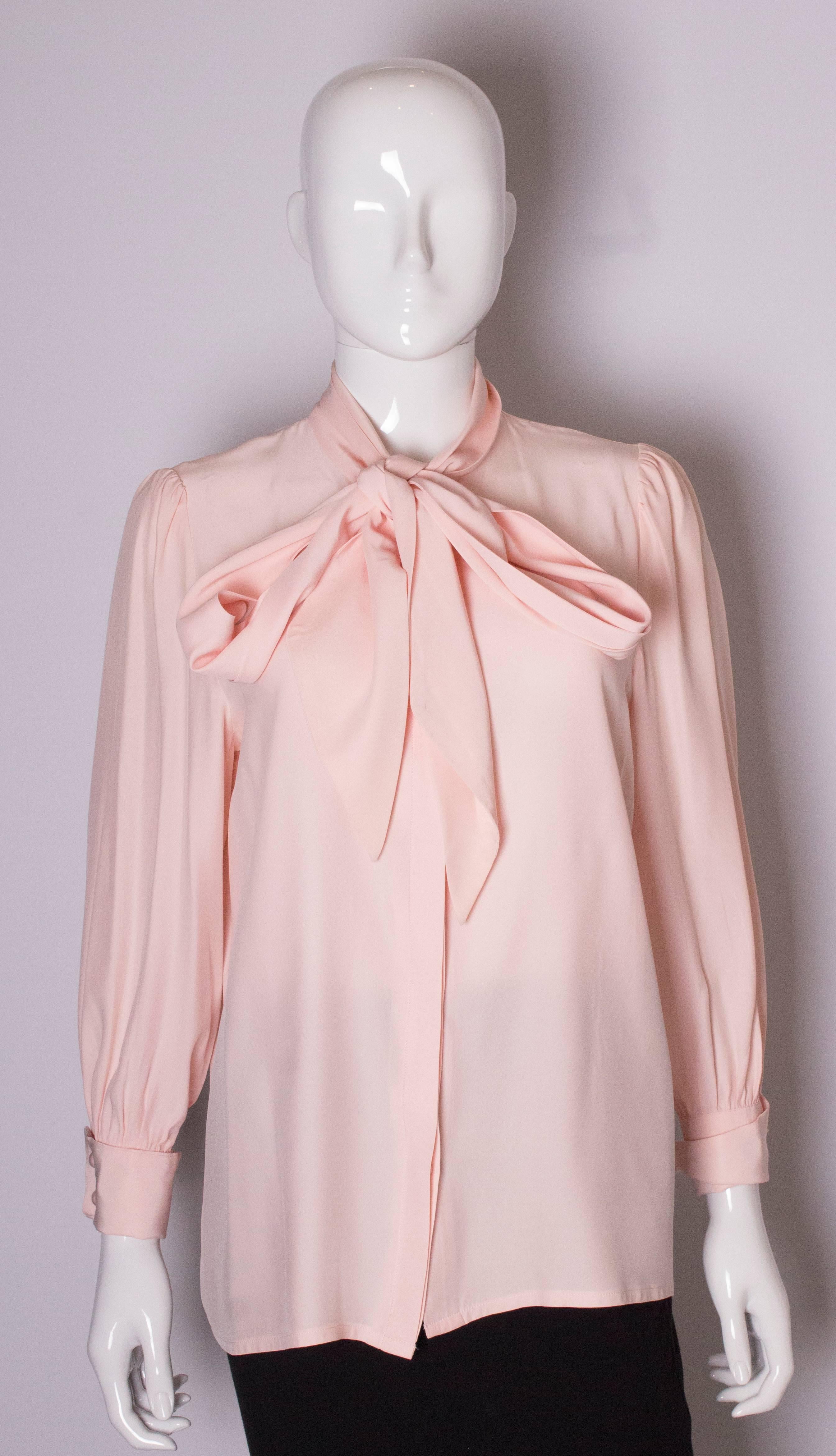 A chic pink silk blouse by Hardy Amies. The blouse has a tie neck and double cuffs.