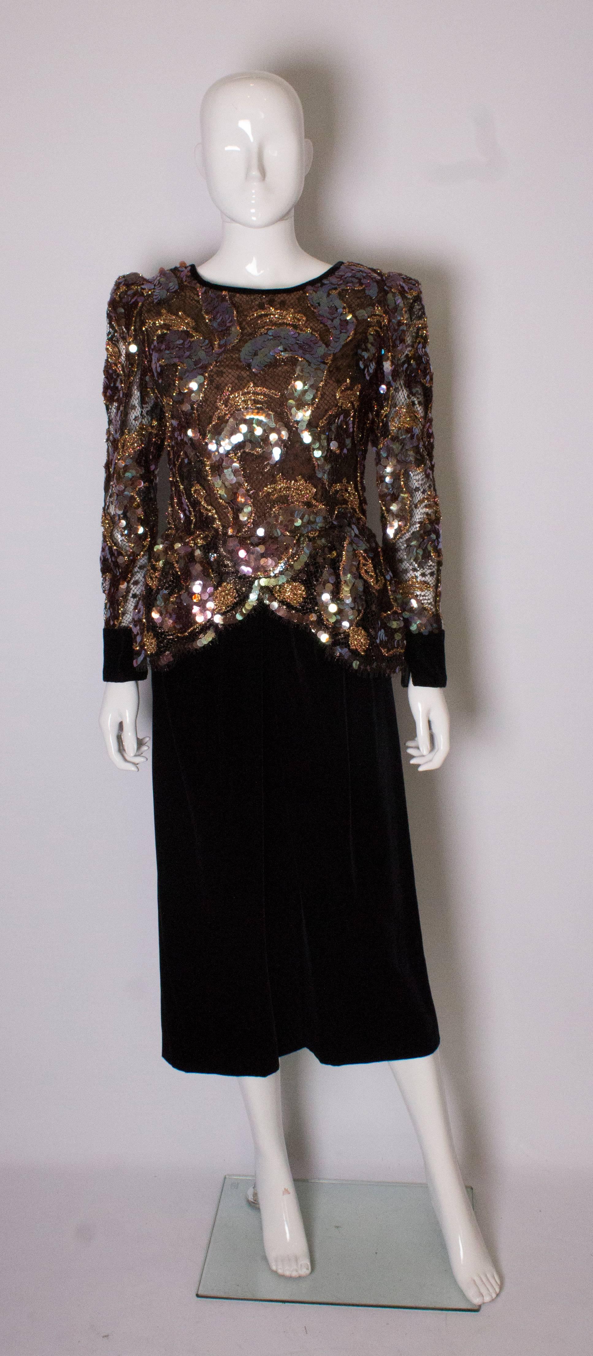 A stunning cocktail dress, the body is sequins and trim on net  ( lined) with the same fabric on the sleeves but unlined. The body has a wrap over peplum, and a scoop neckline at the back. The skirt is a rich brown velvet.