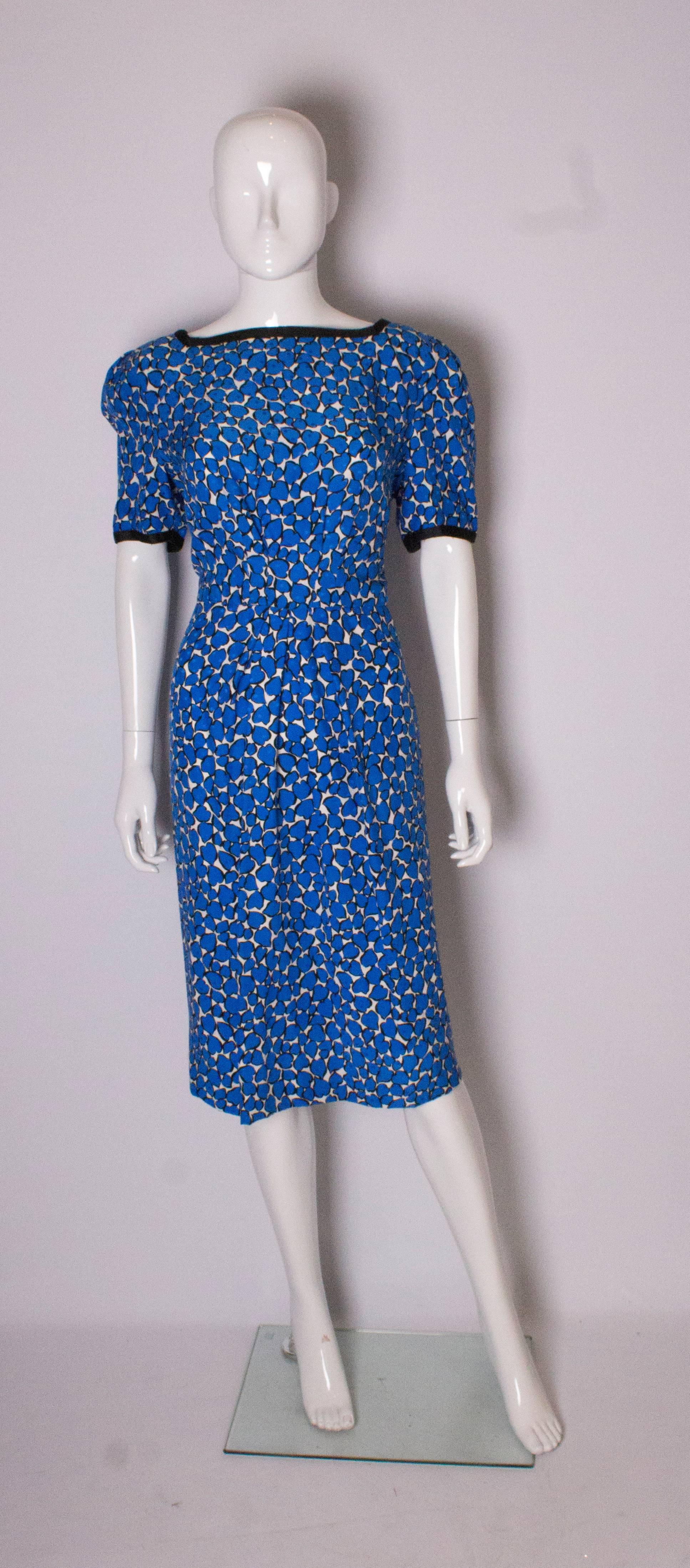 A chic dress by British designer Donald Campbell, in a blue and white silk designed by Abraham of Switzerland. The dress has a black band around the neck and cuffs, a central back zip and is fully lined.