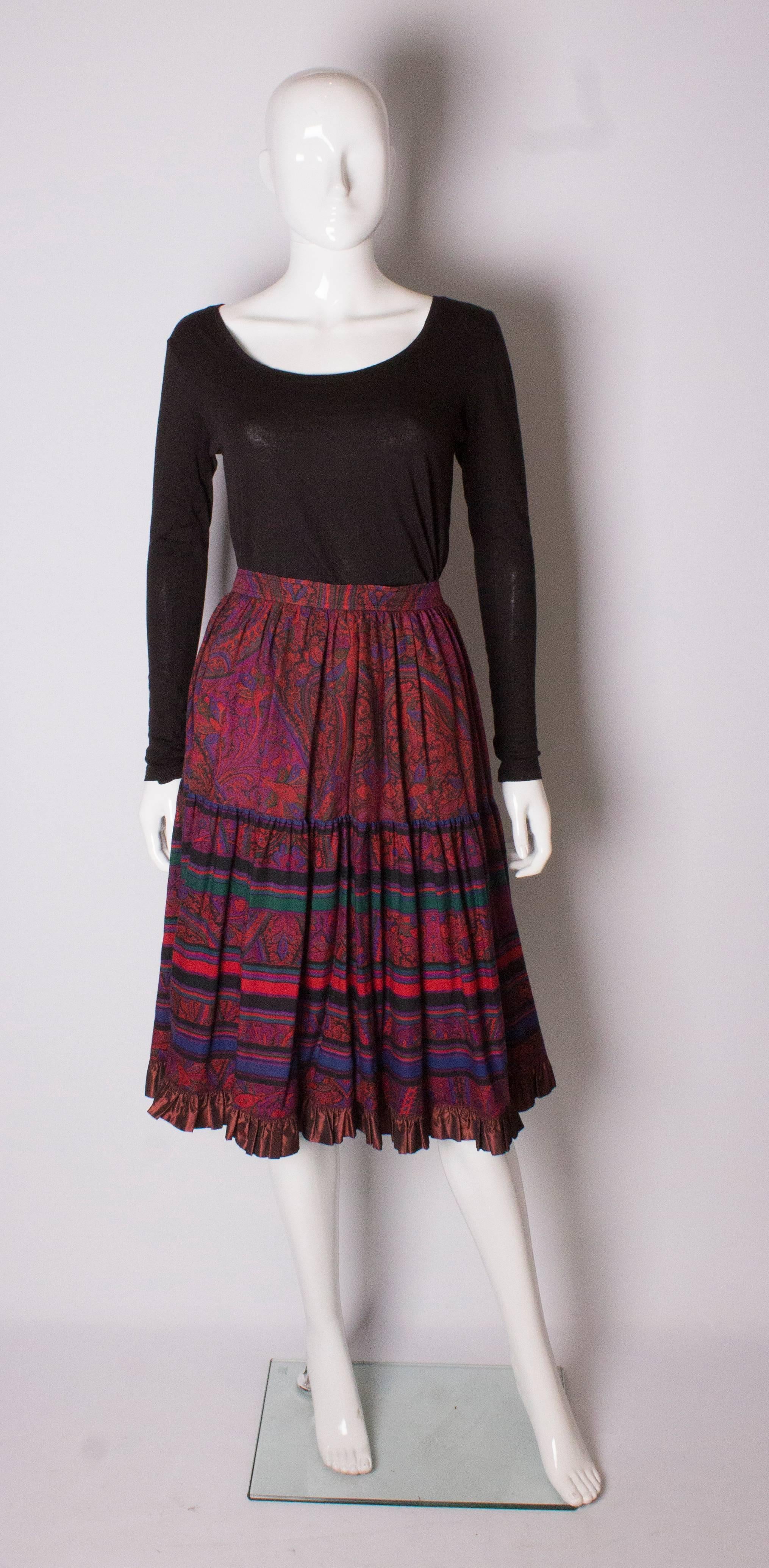 Yves Saint Laurent Rive Gauche paisley print skirt in a wonderful colour palete of pinks and and purples.The skirt has one pocket on either side and a satin frill at the hem.