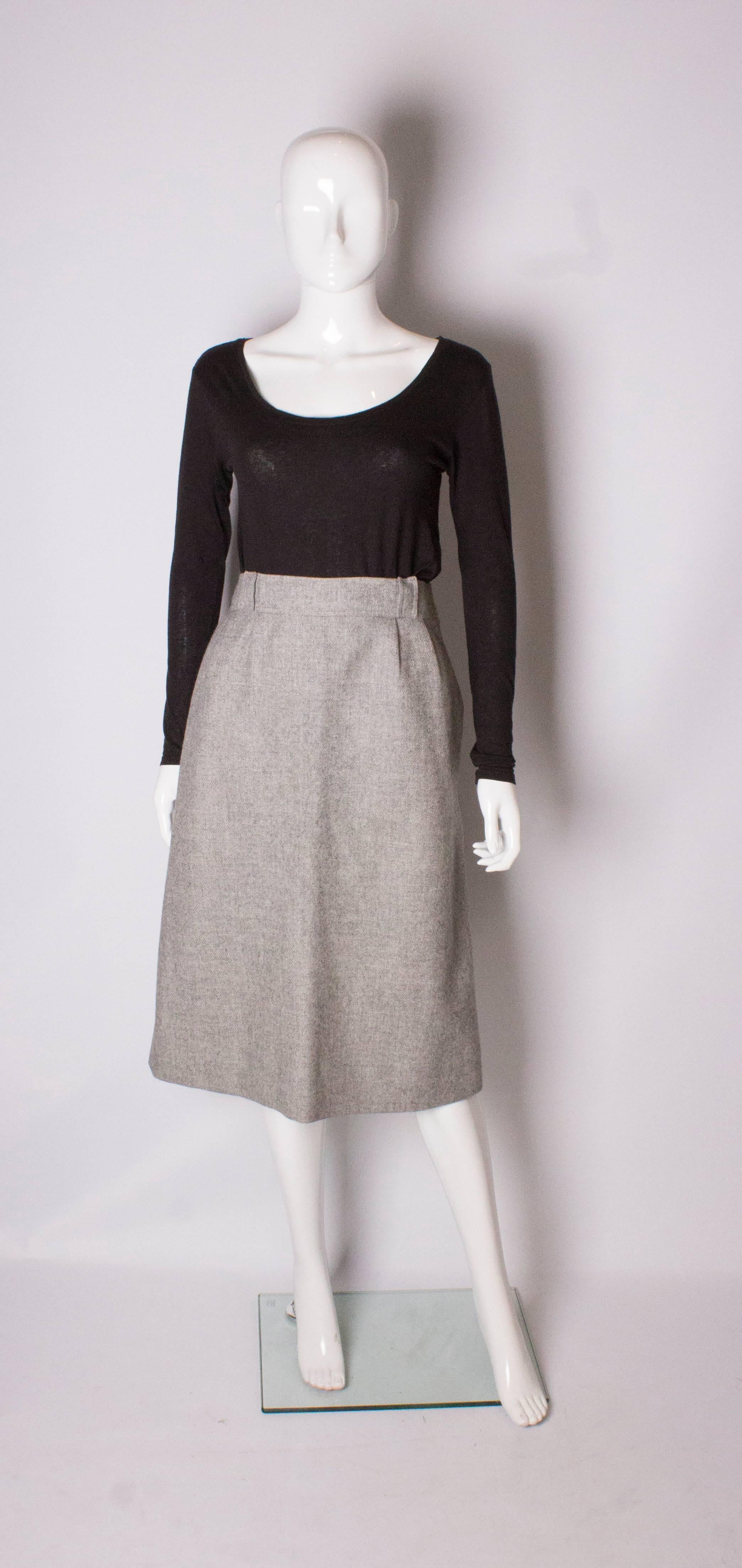 A chic skirt by Courreges. In a grey wool, with belt hoops, a pocket on either side and  8 1/2'' slit on either side. The skirt is fully lined.                                                                                                     