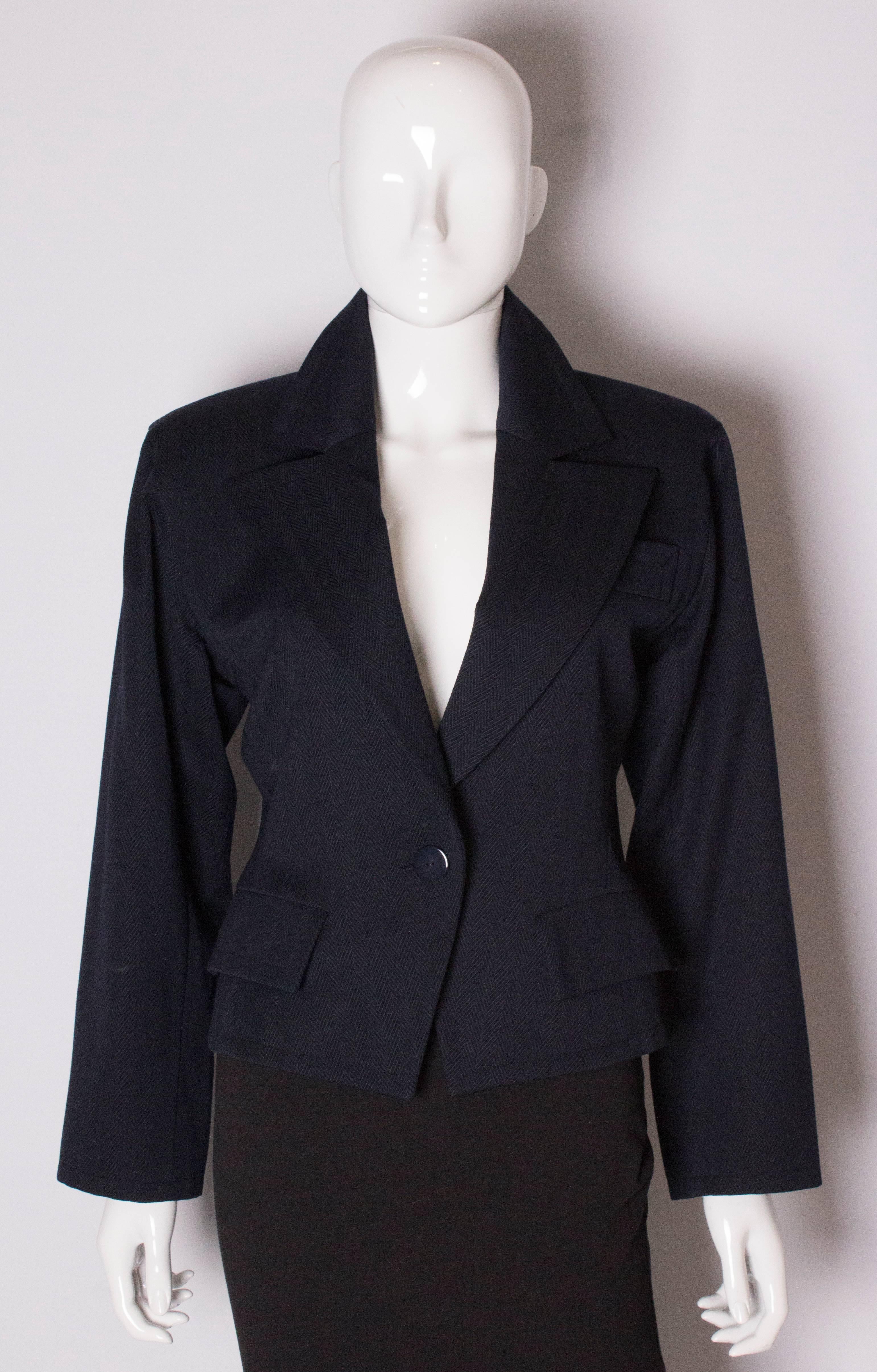 A chic jacket by Yves Saint Laurent  Variation line. The jacket is in a dark blue  herring bone like fabric and has one breast pocket and two smaller pockets at hip leval. It has one central button fastening and one button on each cuff.
Bust 36'',