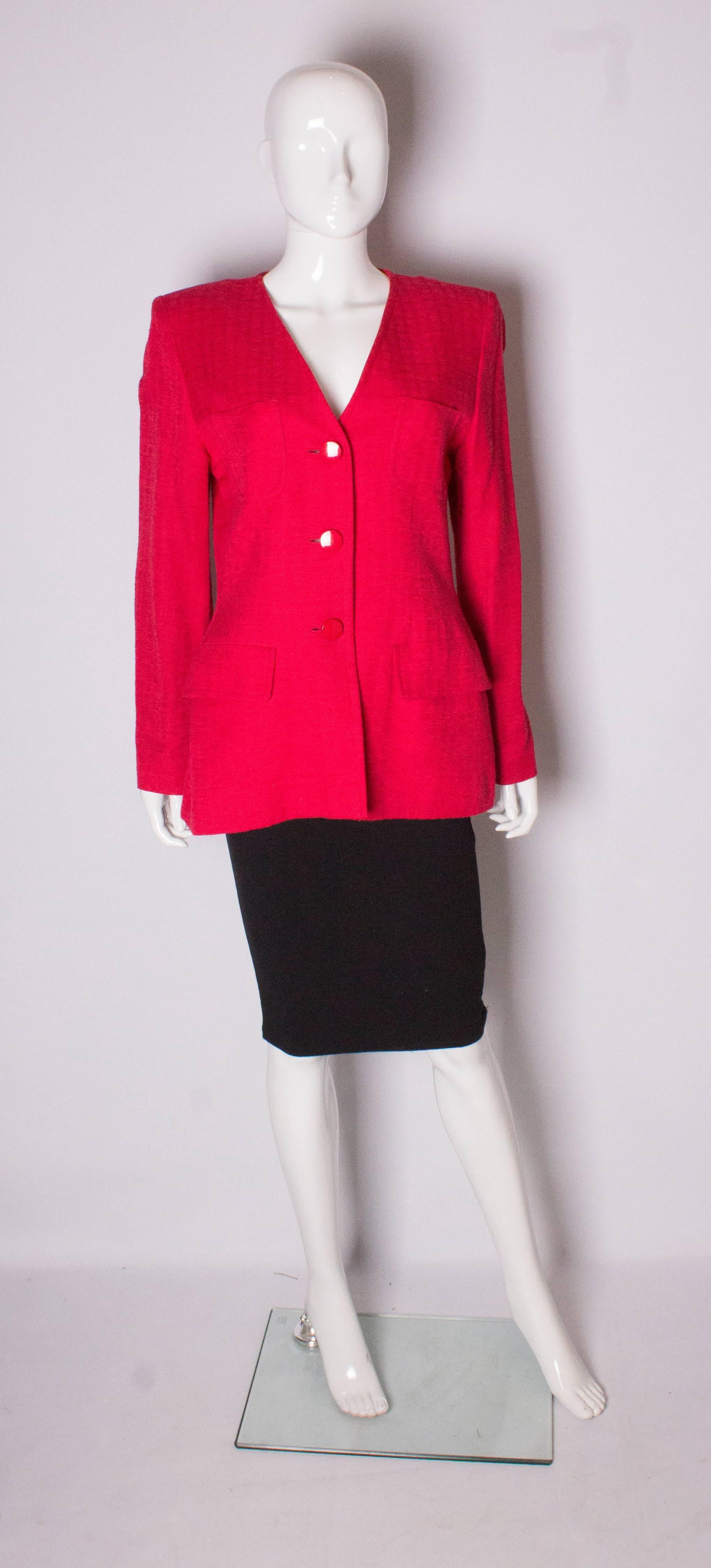 A vintage red jacket by Yves Saint Laurent , Variation line. In a textured fabric, the jacket has a v neck , 2 breast pockets, and 2 pockets at waist leval and a 3 button opening at the front.