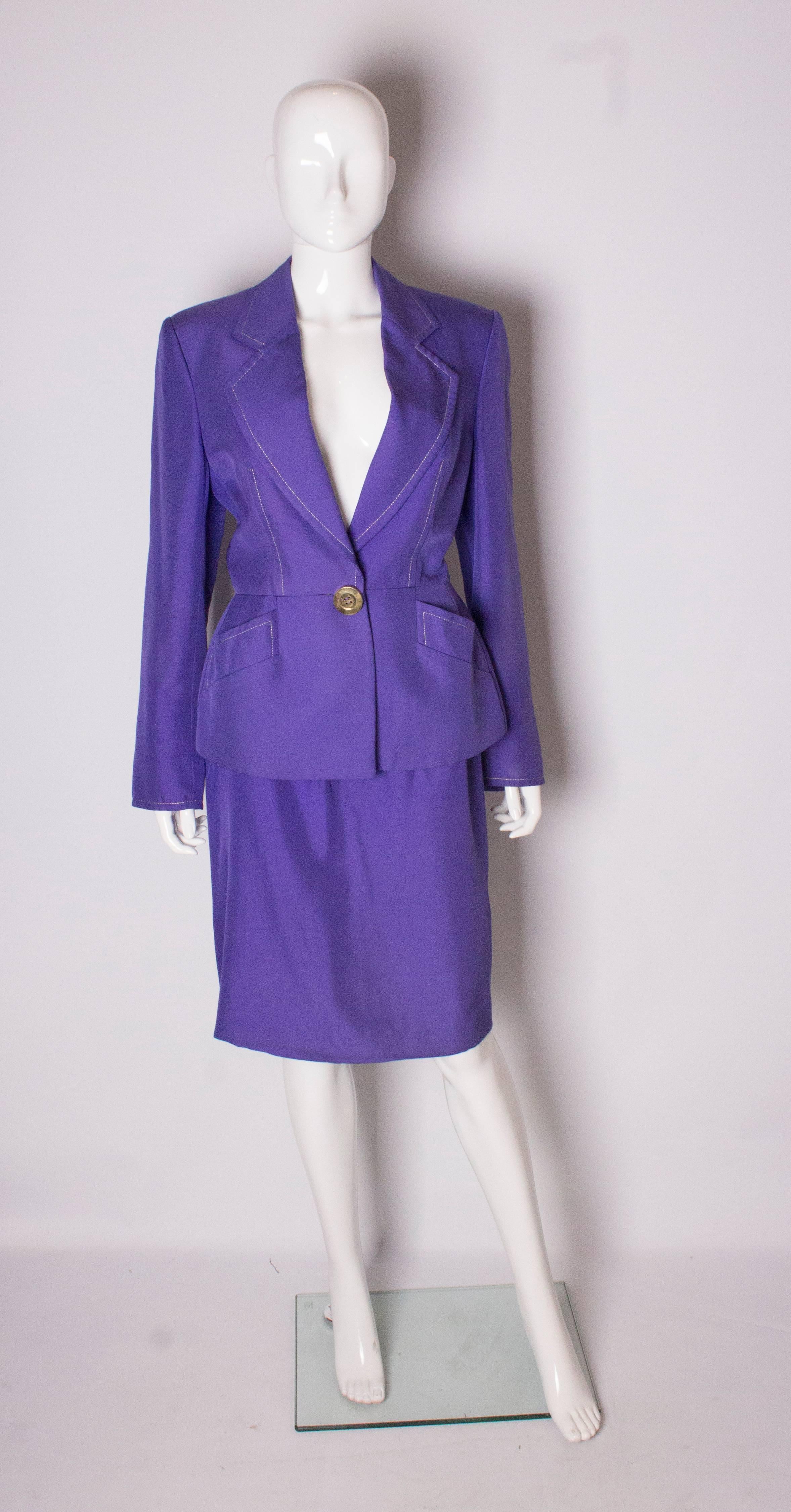A stunning vintage silk  suit by Christian Dior in this season colour, purple.
The jacket has a v neckline with gold thread , 2 pockets at waist leval and a one button fastening. It is lined in silk and number 84017, and size 42.
The matching pencil