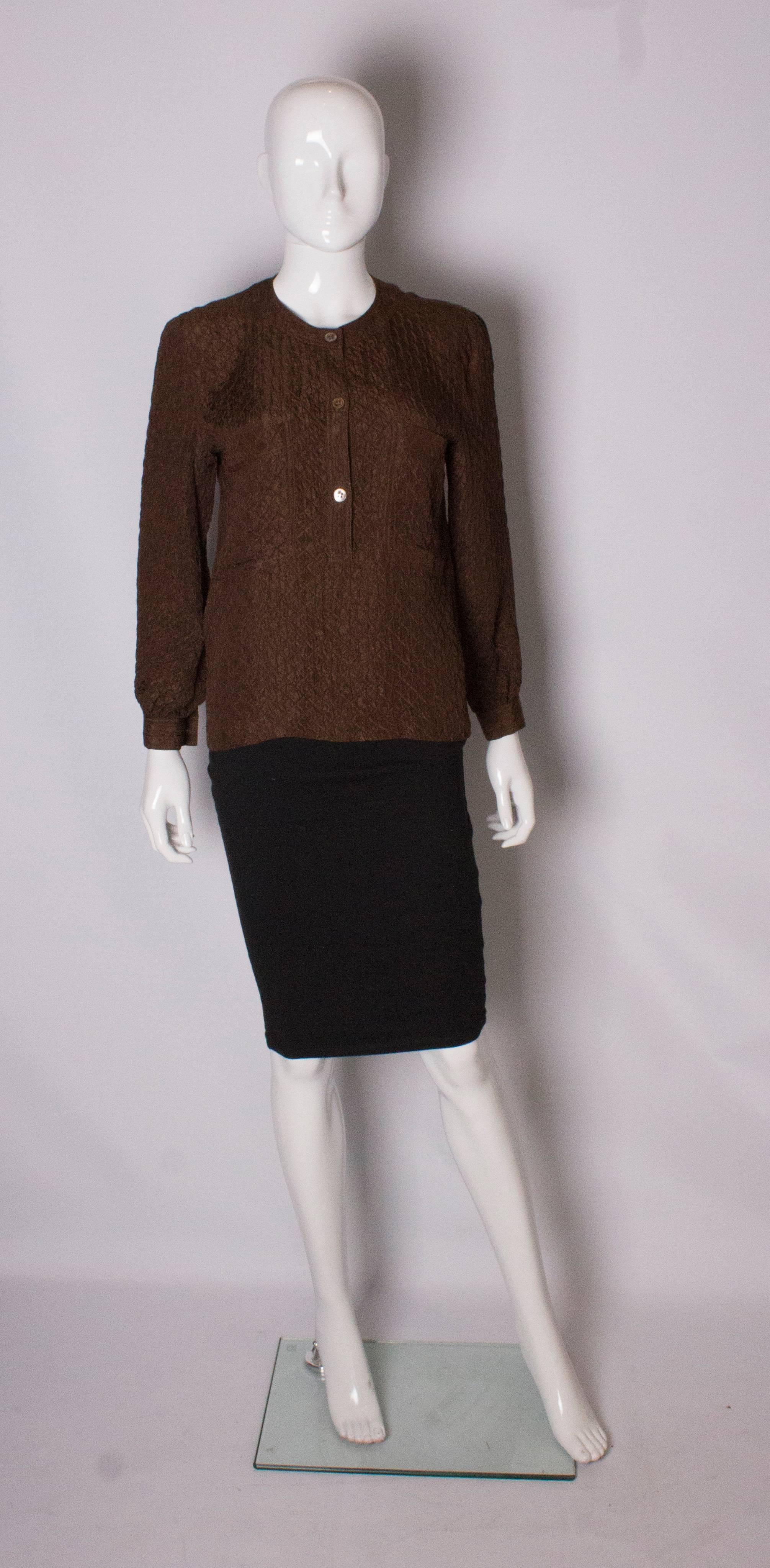 A chic top by Valentino, Miss V line. The top is in a brown quilted silk and has a v neckline with 3 button front opening and one button on the cuffs. It has two breast pockets.