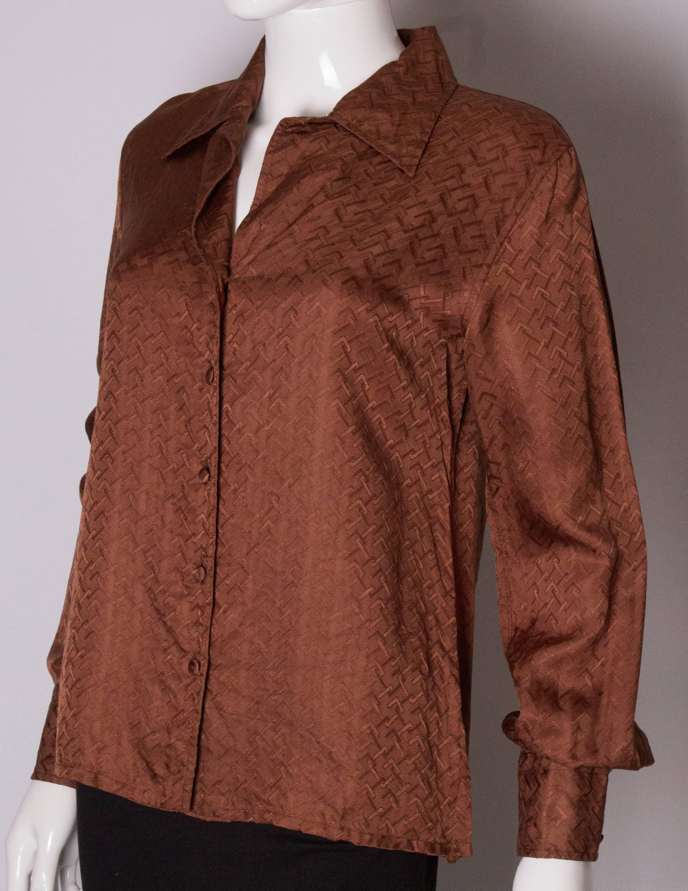A great silk shirt by Gucci. In a brown textured silk, the shirt has a five button opening with  silk covered buttons, and two button cuffs.