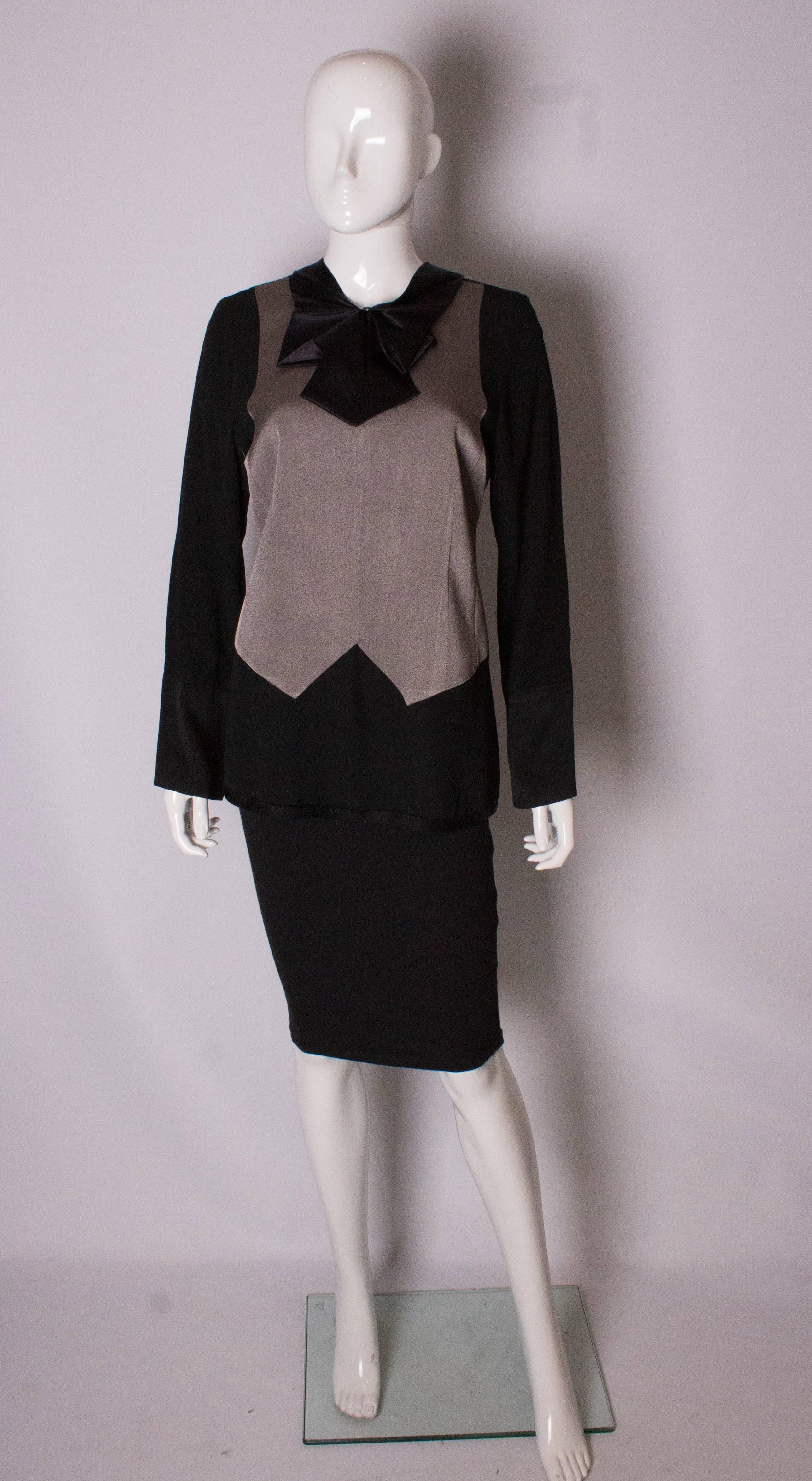 A chic top by Marc Jacobs. In grey and black, the top has a zip opening at the back, ribbon detail at the neck and hem and a satin bow at the front.