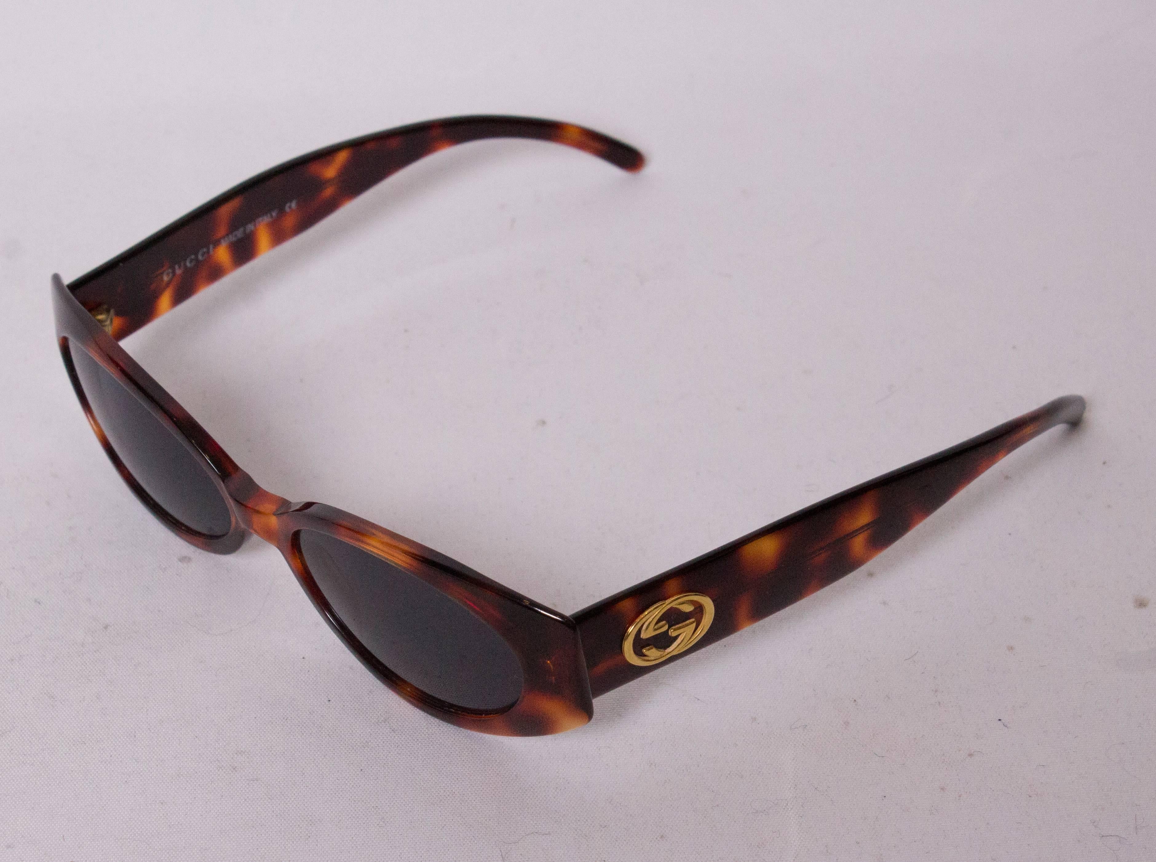 A chic pair of Gucci sunglasses with tortoise shell frames.They have the double G logo on the arm, and the serial number is 145 GG 2196 /S