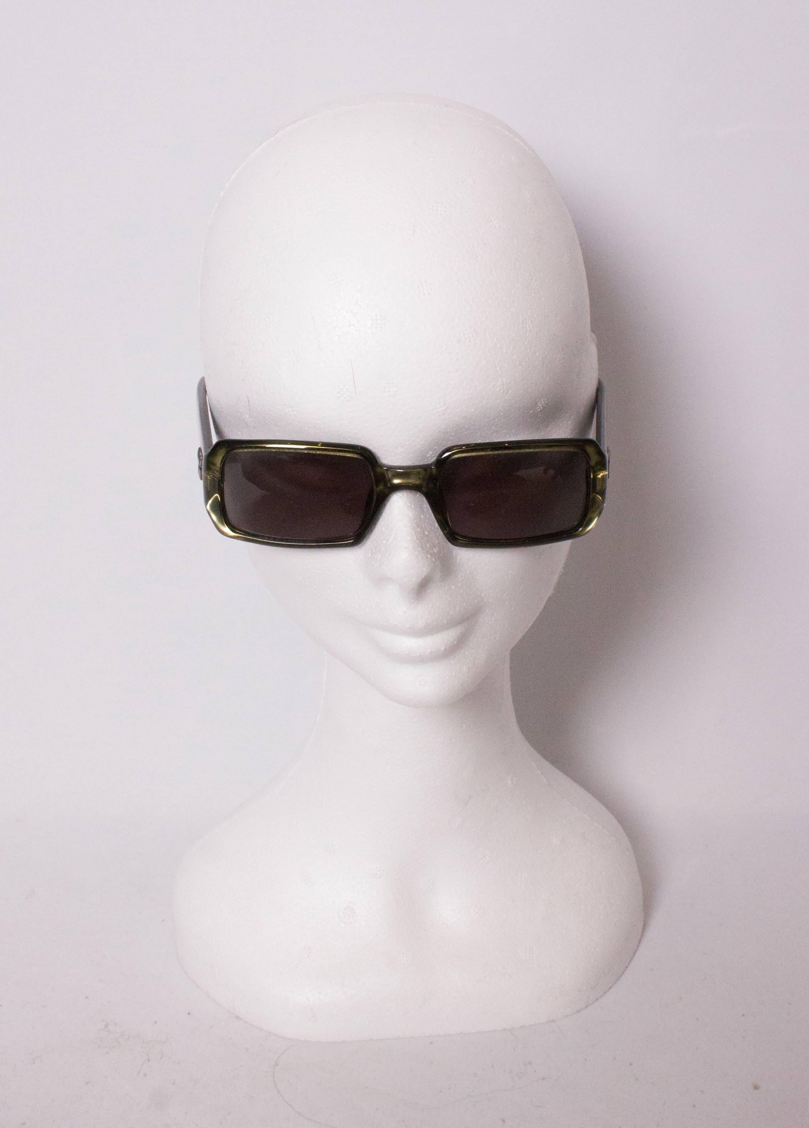 A chic pair of sunglasses by Gucci. The have olive green frames and the Gucci logo on  the arms. Model number 135GG11765., box included.
