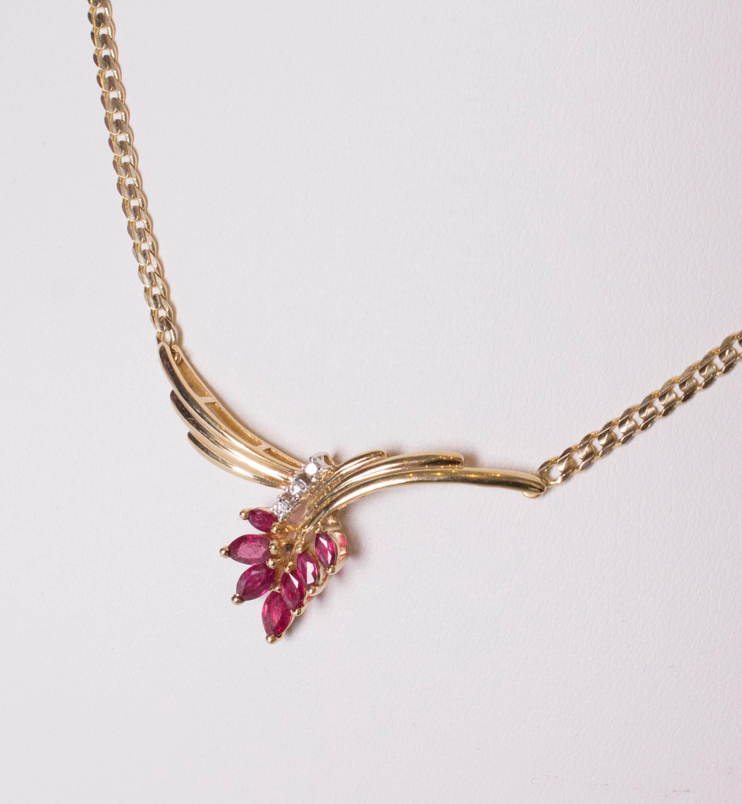A stunning ruby, diamond and gold necklace.  The pendant is composed of 7 rubies, 3 diamonds, set in gold in a wing like design.