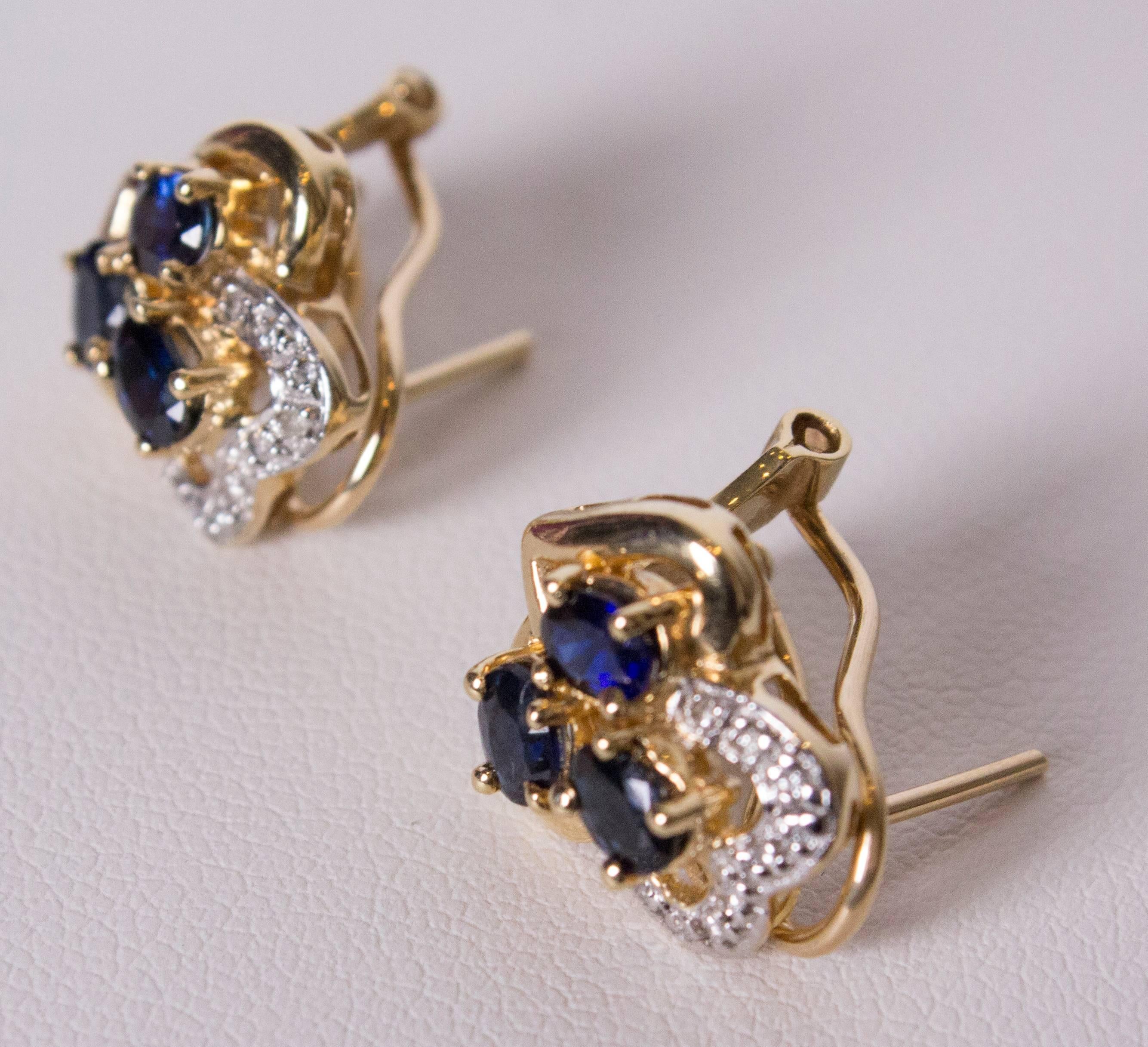 A pretty pair of earrings for Spring. The earrings have three saphires, one surrounded by diamonds, set in gold with a folding clasp at the back. width 1/2'', height 1/2''