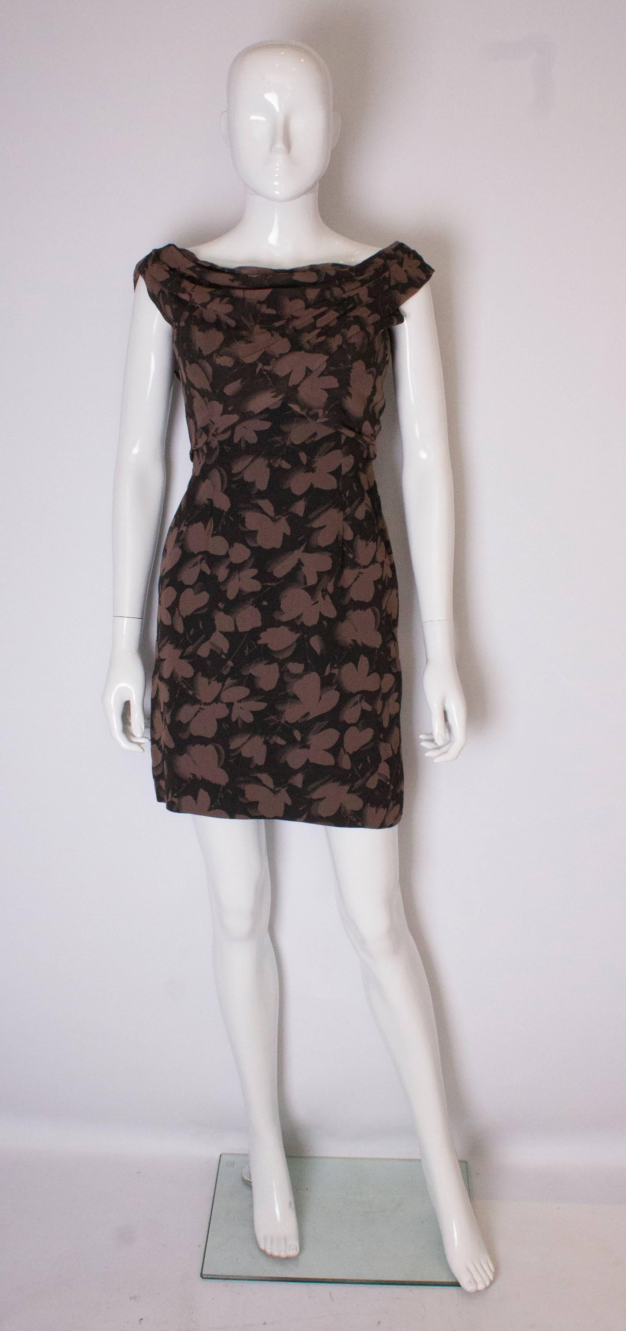 A pretty  1950 's cocktail dress The dress has  a black background and blush pink floral print. It   is fully lined, with a drape over front , and scoop back.