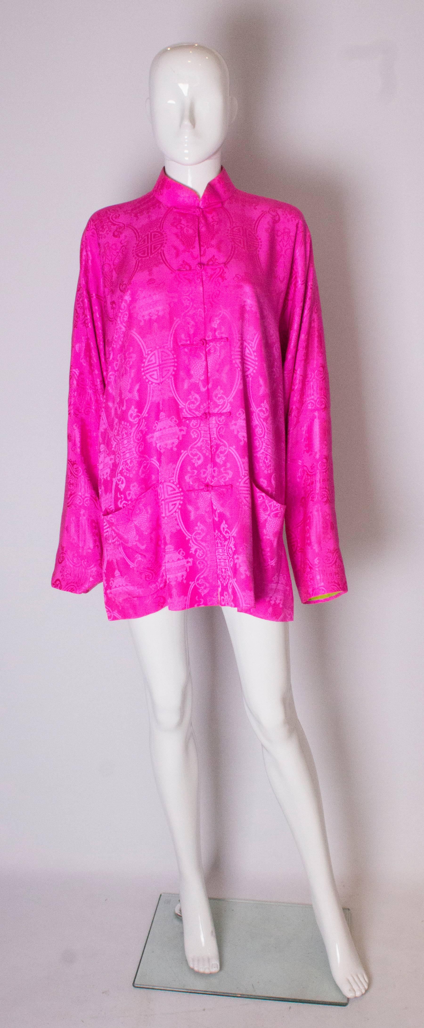 A stunning jacket for summer by Shanghai Tang. It is a wonderful bright pink silk on the outside and stunning lime green silk on the inside. The jacket has two pockets on the outside ,one on the inside and 6 1/2 '' slit on either side. it is meant