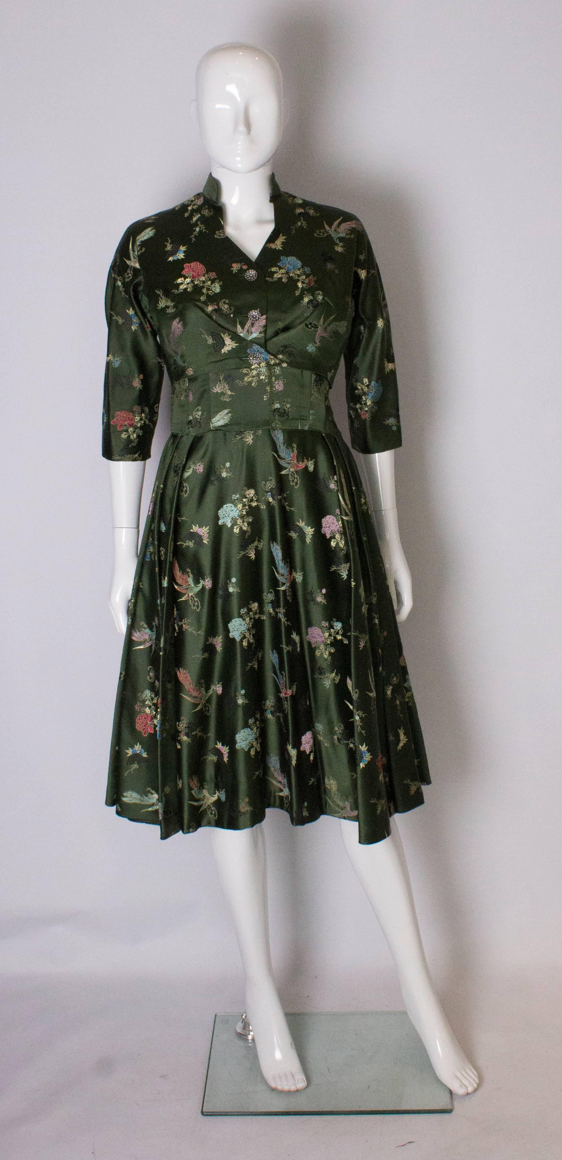 A pretty green cocktail dress and matching bolero jacket.  The dress has a boned bodice, with a flared skirt and side zip. The jacket has a three button fastening. Both the dress and jacket are fully lined.  Measurements: Dress, bust 36'', waist