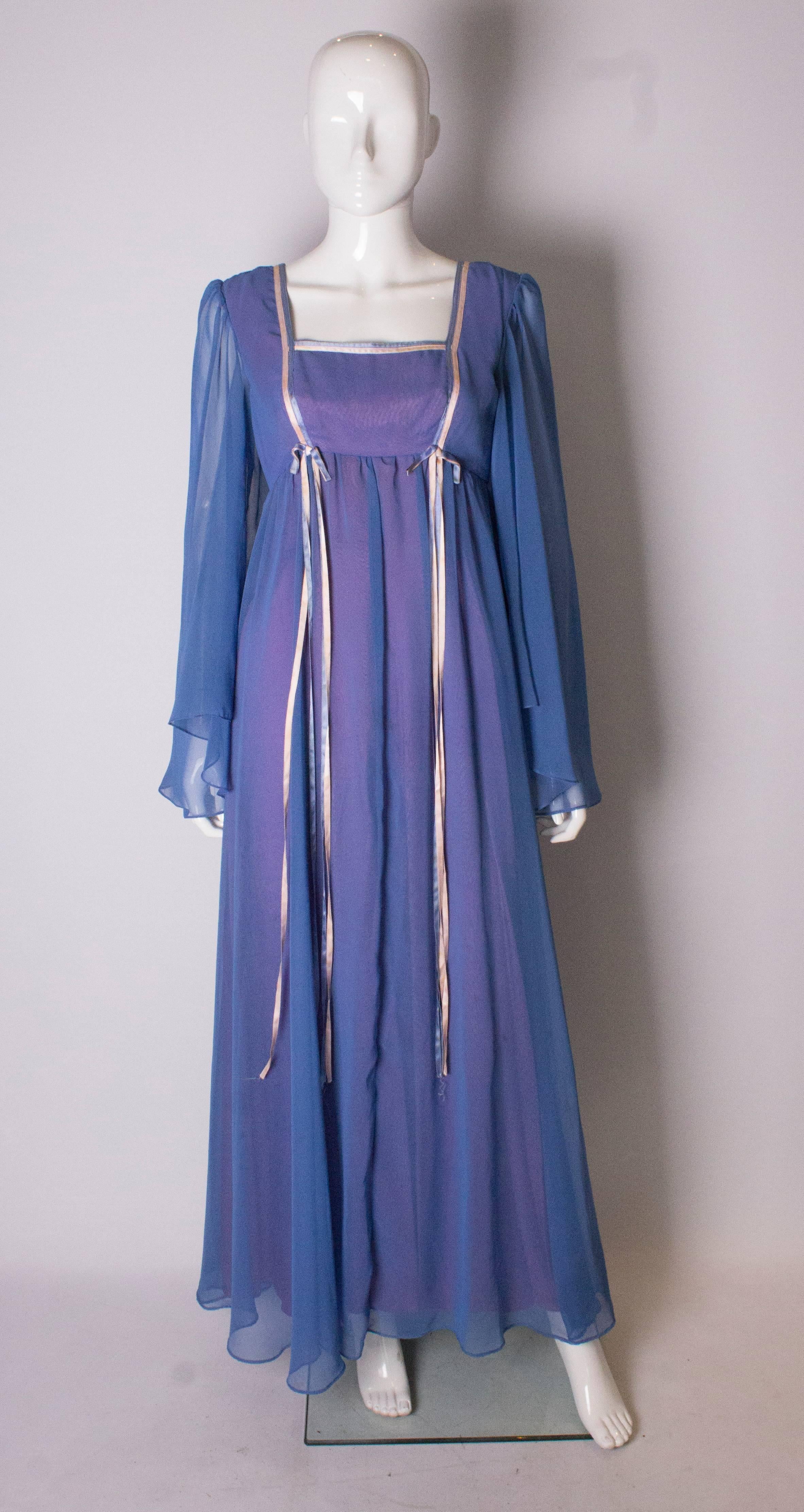 A vintage 1970s lilac gown by California ' . In a blue outer fabric with a lilac lining, the dress has a square neckline with ribbon detail and long sleeves. 