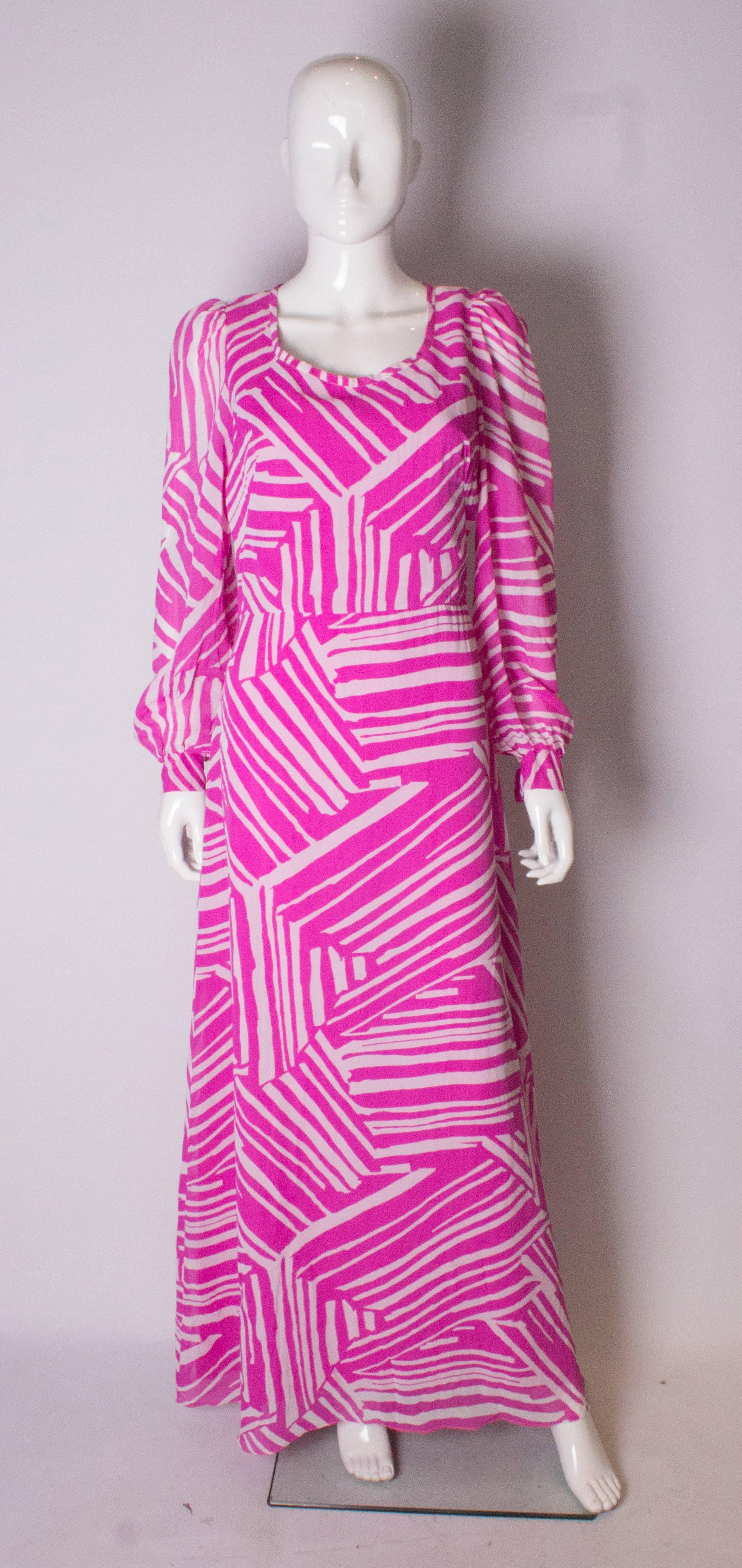 A pretty and easy to wear dress for Summer. In an abstract pink and white print, the dress has a round neckline, long sleeves with a  two button cuff,  and a central back zip. 
