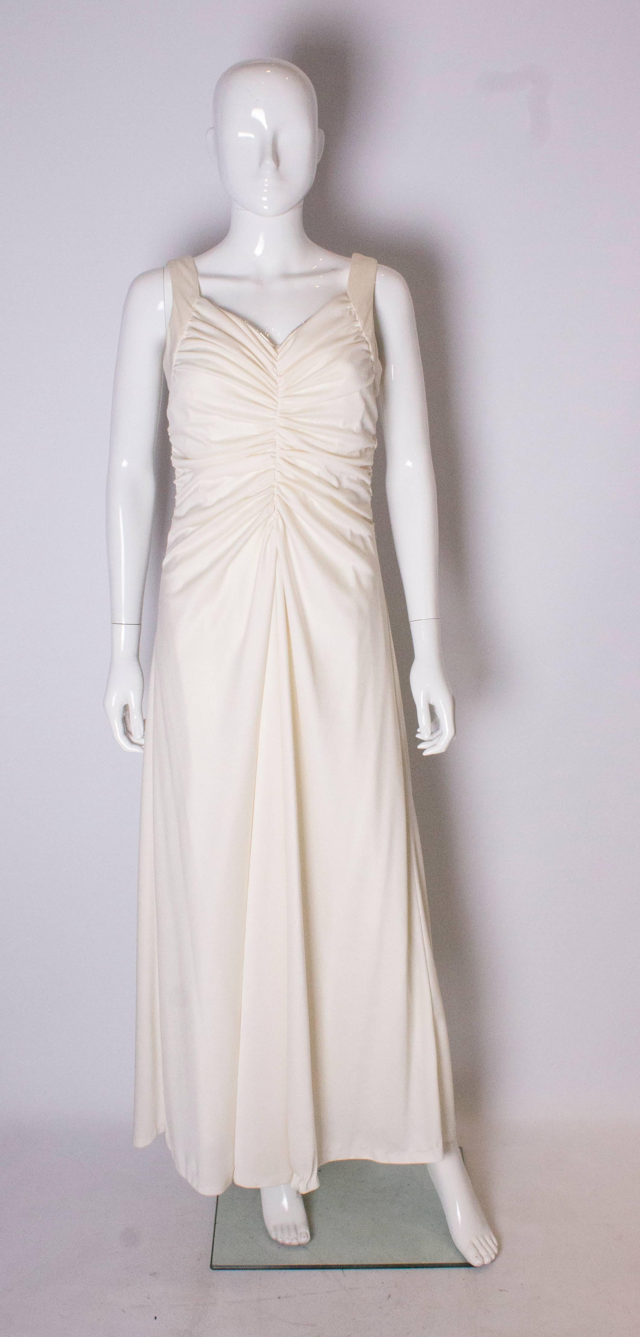A great dress for summer in white with a silver trim.The dress has gathering at the front and back , and drapes from  below the bust. it has a central back zip , and is fully lined.