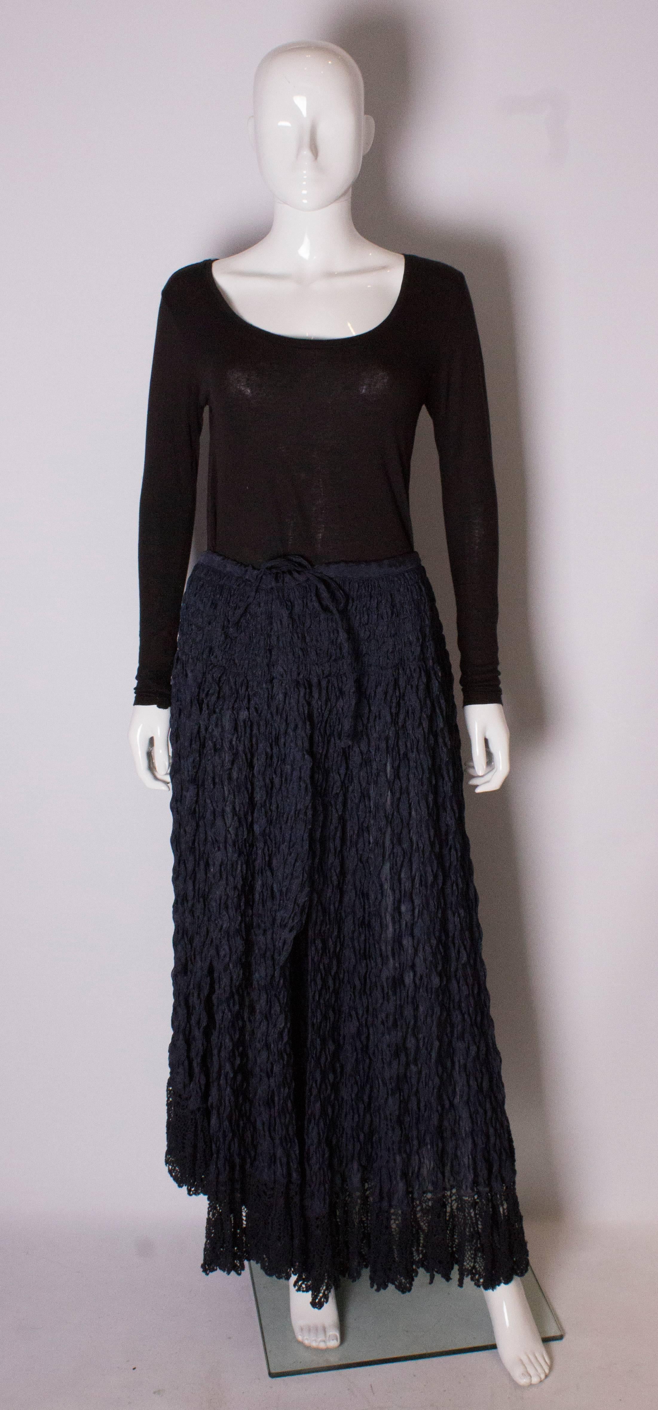 A lovely vintage blue skirt by Romeo Gigli. The skirt has  drawstring waist, and is made of a textured fabric with a lace trim at the hem, and has several slits .