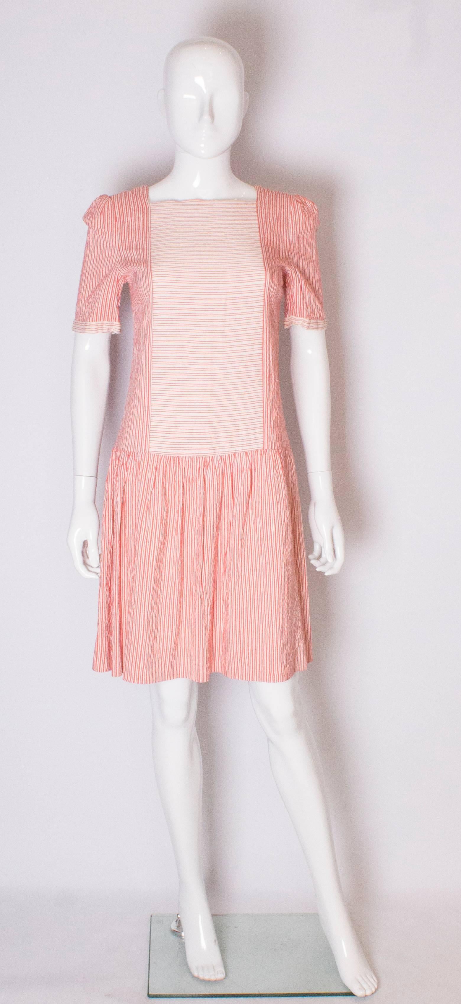 A cute vintage cotton  dress by Gina Fratini. The dress is in a red  and white stripe fabric, with a square neckine , drop waist and short sleeves . The skirt is fully lined.